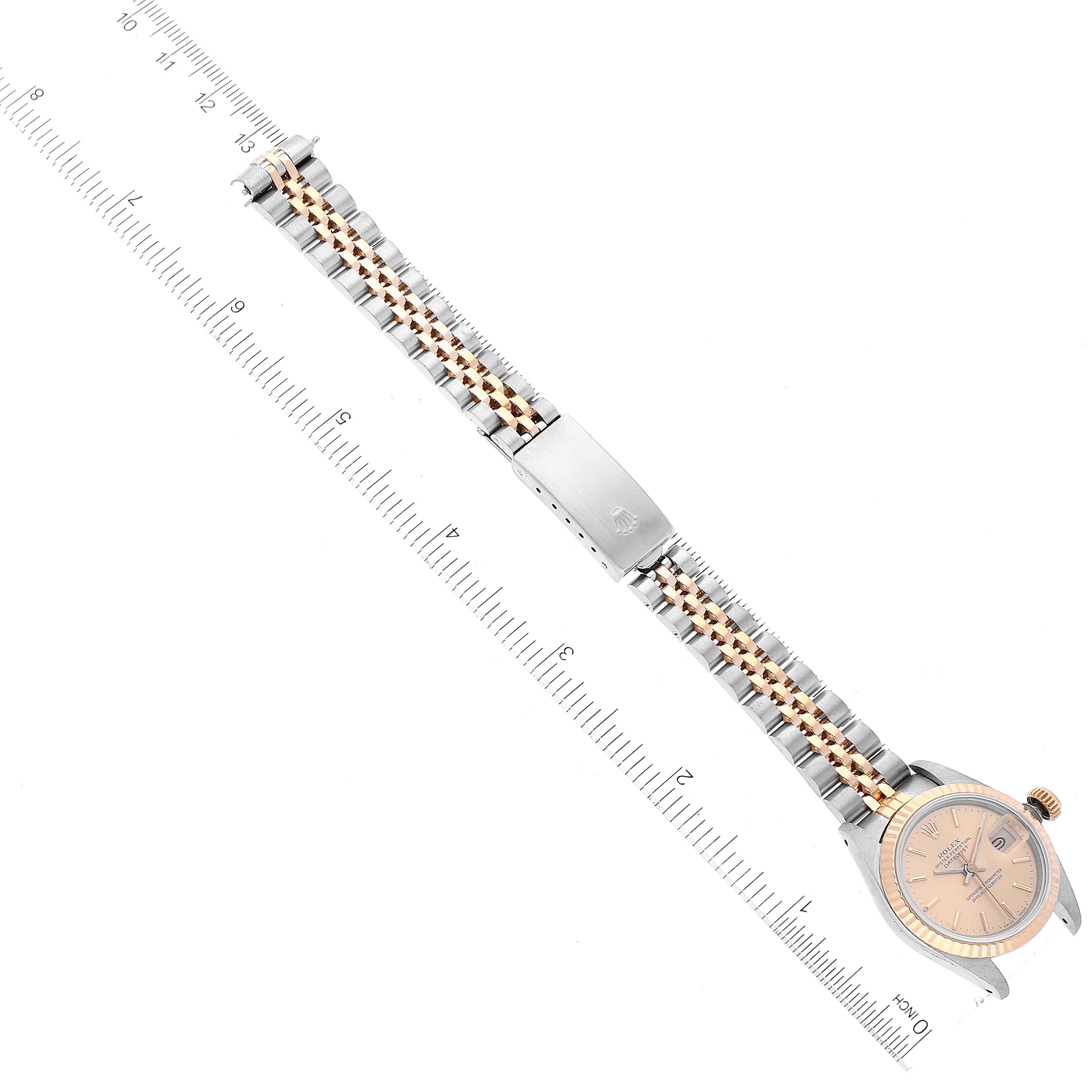 The image shows a top-down view of the Rolex Datejust 69173 Women's Steel and Gold (two tone) Champagne Dial 69173 Women's Steel and Gold (two tone) Champagne Dial watch, highlighting its case, dial, bracelet, and clasp next to a ruler.