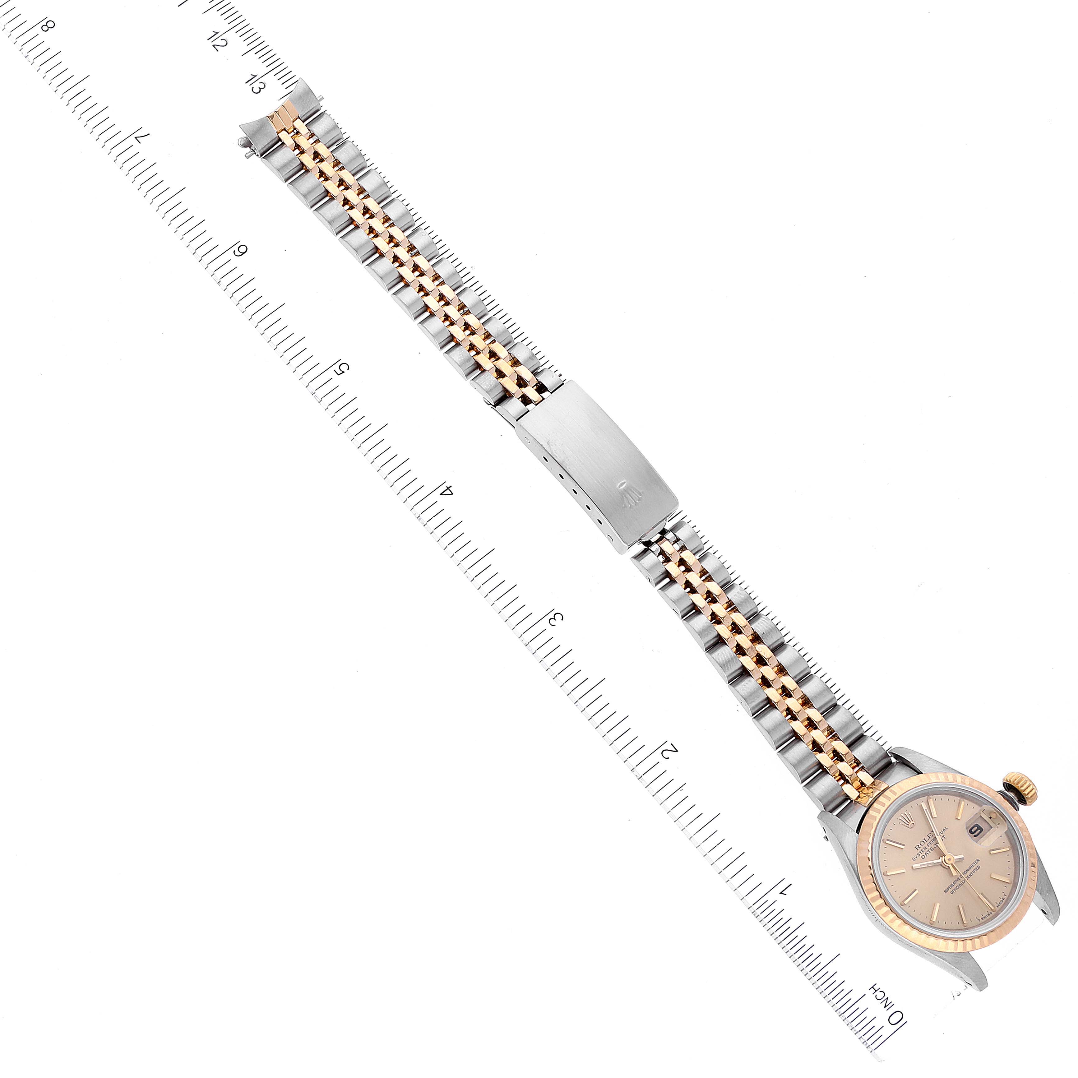 A top-down view of a Rolex Datejust 69173 Women's Steel and Gold (two tone) Champagne Dial 69173 Women's Steel and Gold (two tone) Champagne Dial watch, showing the dial, case, bezel, and full bracelet next to a ruler for scale.