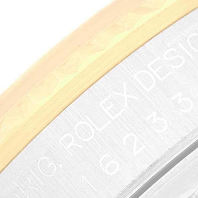 The image shows a close-up of the engraved side of the case and the bezel of a Rolex Datejust 16233 Men's Steel and Gold (two tone) Silver Dial 16233 Men's Steel and Gold (two tone) Silver Dial watch.