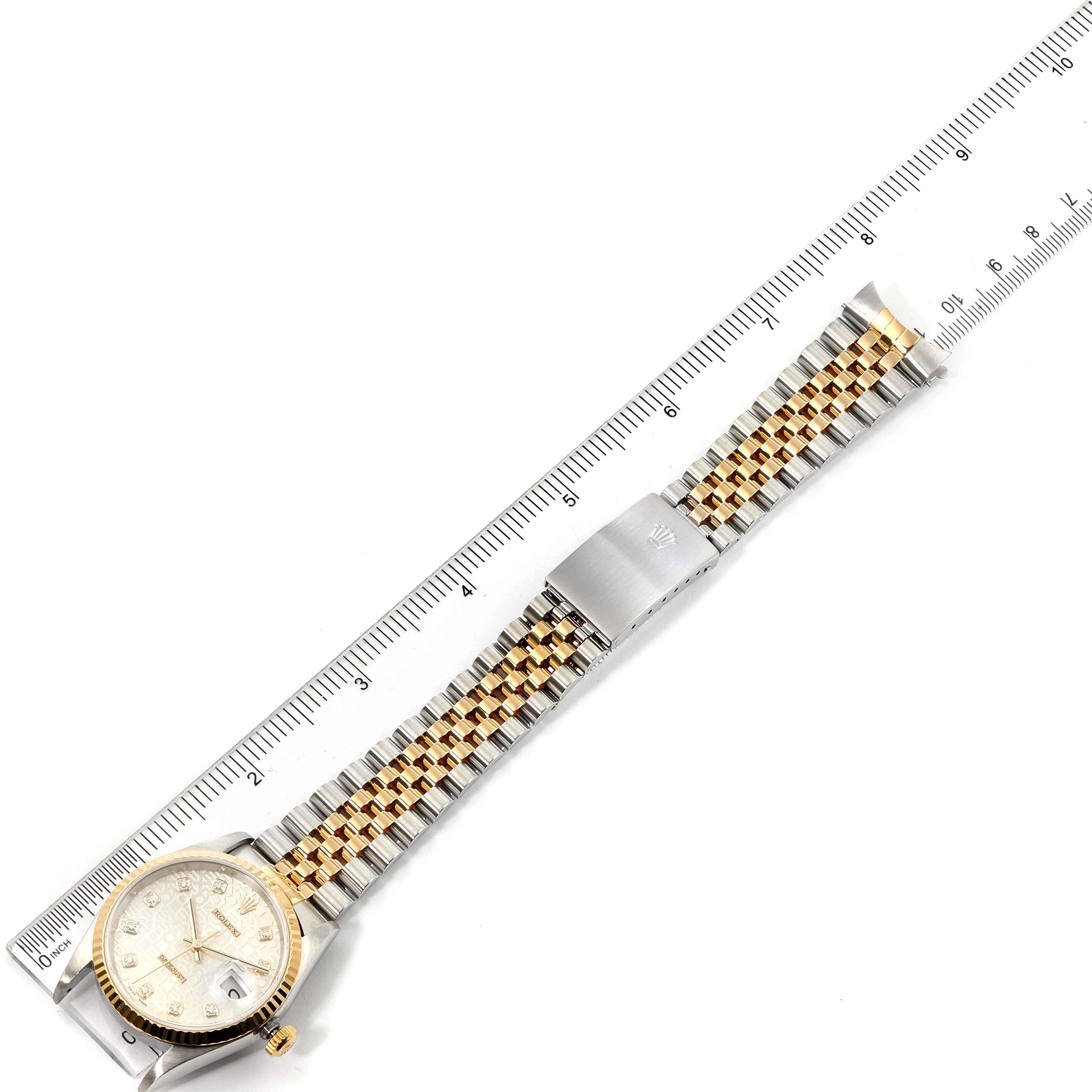 The image shows a top view of the Rolex Datejust 16233 Men's Steel and Gold (two tone) Silver Dial 16233 Men's Steel and Gold (two tone) Silver Dial watch, highlighting the face, band, and clasp against a ruler.