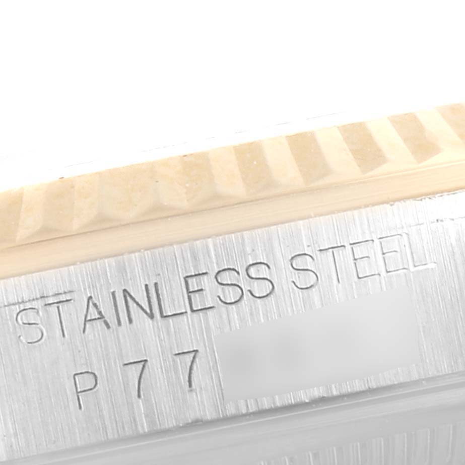 This image shows a close-up of the Rolex Datejust 16233 Men's Steel and Gold (two tone) Silver Dial 16233 Men's Steel and Gold (two tone) Silver Dial's fluted bezel and part of the stainless steel case where the serial number is engraved.