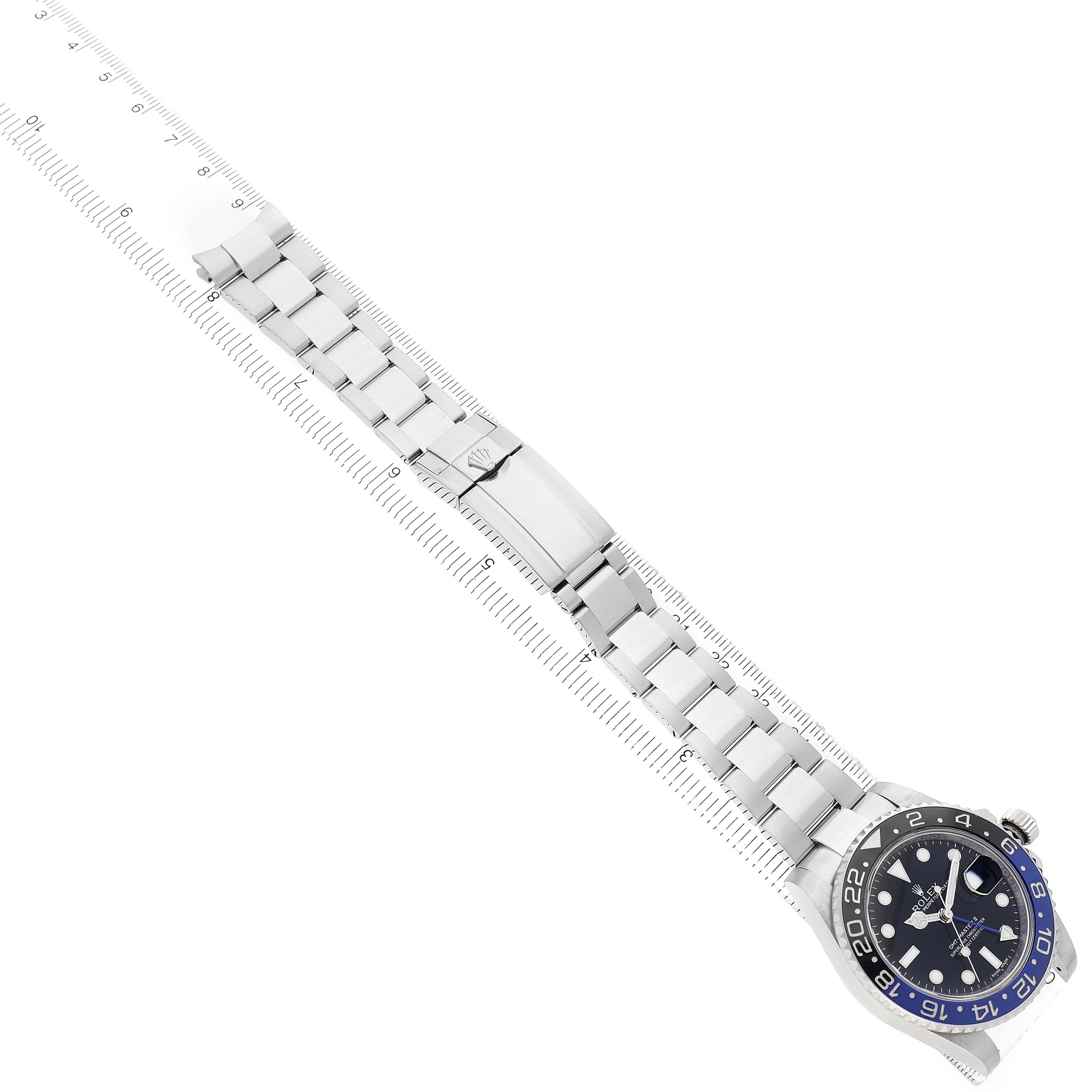 The image shows a top view of the Rolex GMT-Master 116710BLNR Men's Stainless Steel Black Dial watch, highlighting the face, bezel, and full bracelet alongside a ruler.