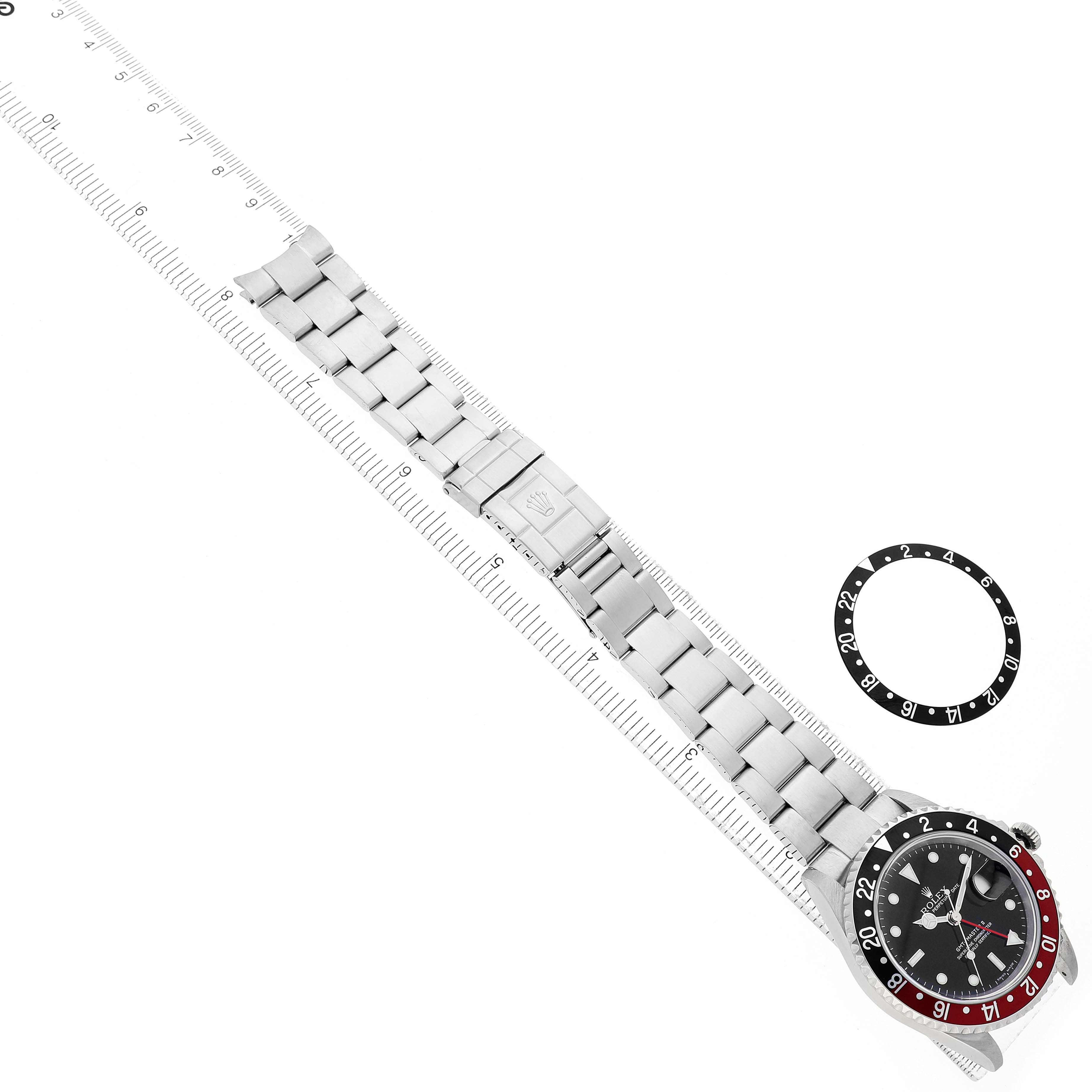 The image shows the Rolex GMT-Master 16710 Men's Stainless Steel Black Dial watch from a top-down angle, displaying the face, bracelet, and an extra bezel.