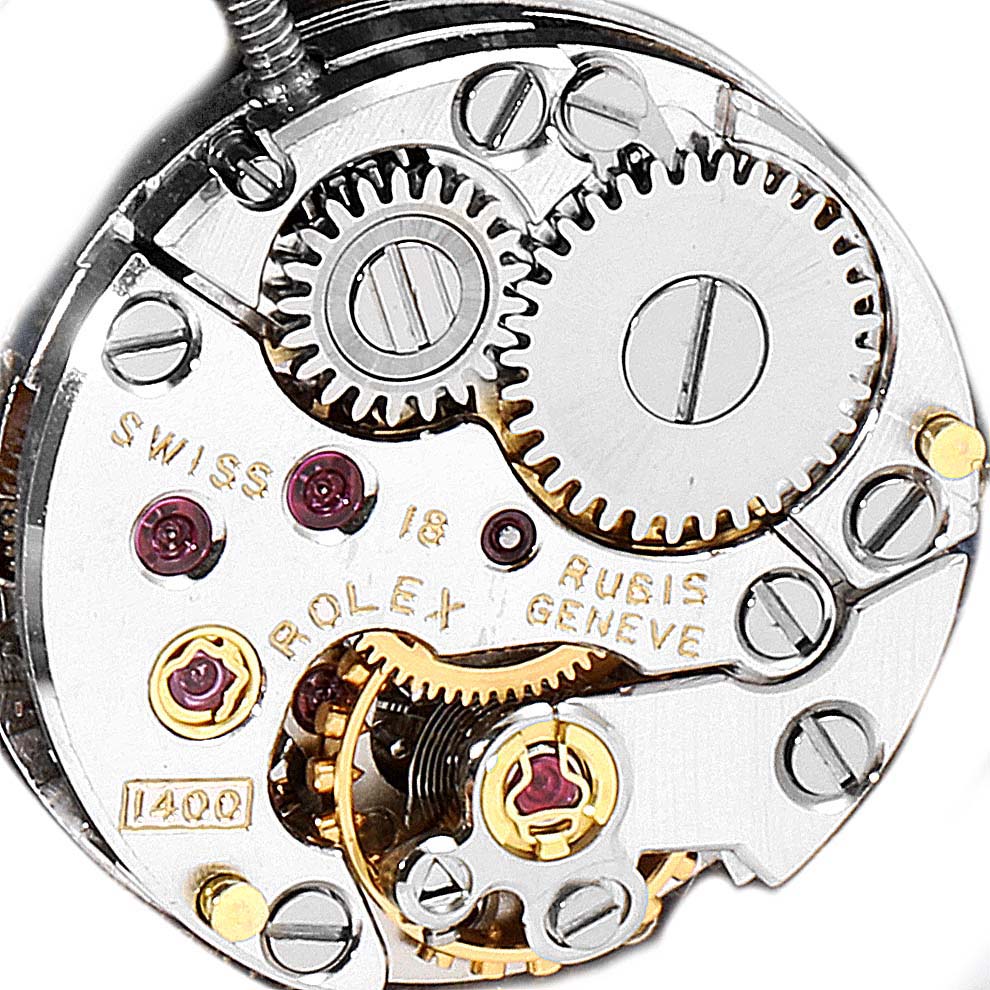 The image shows an internal view of the Rolex Cocktail 2673 Women's White Gold Blue Dial 2673 Women's White Gold Blue Dial model's watch movement mechanism, with visible gears and jewels.