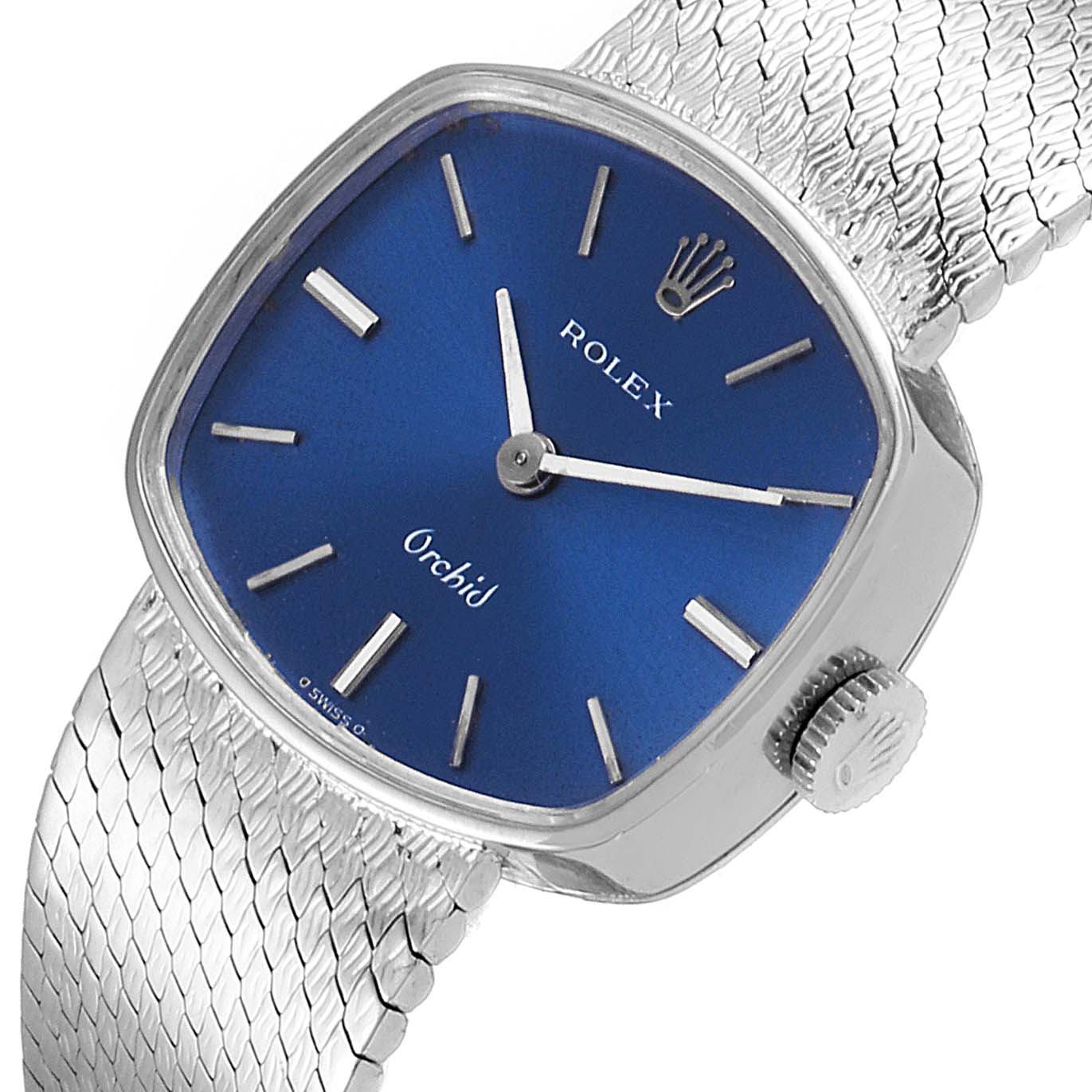 The image shows a Rolex Cocktail 2673 Women's White Gold Blue Dial 2673 Women's White Gold Blue Dial Orchid model watch with a blue dial, silver hour markers, and a mesh band, viewed from an angled top-down perspective.
