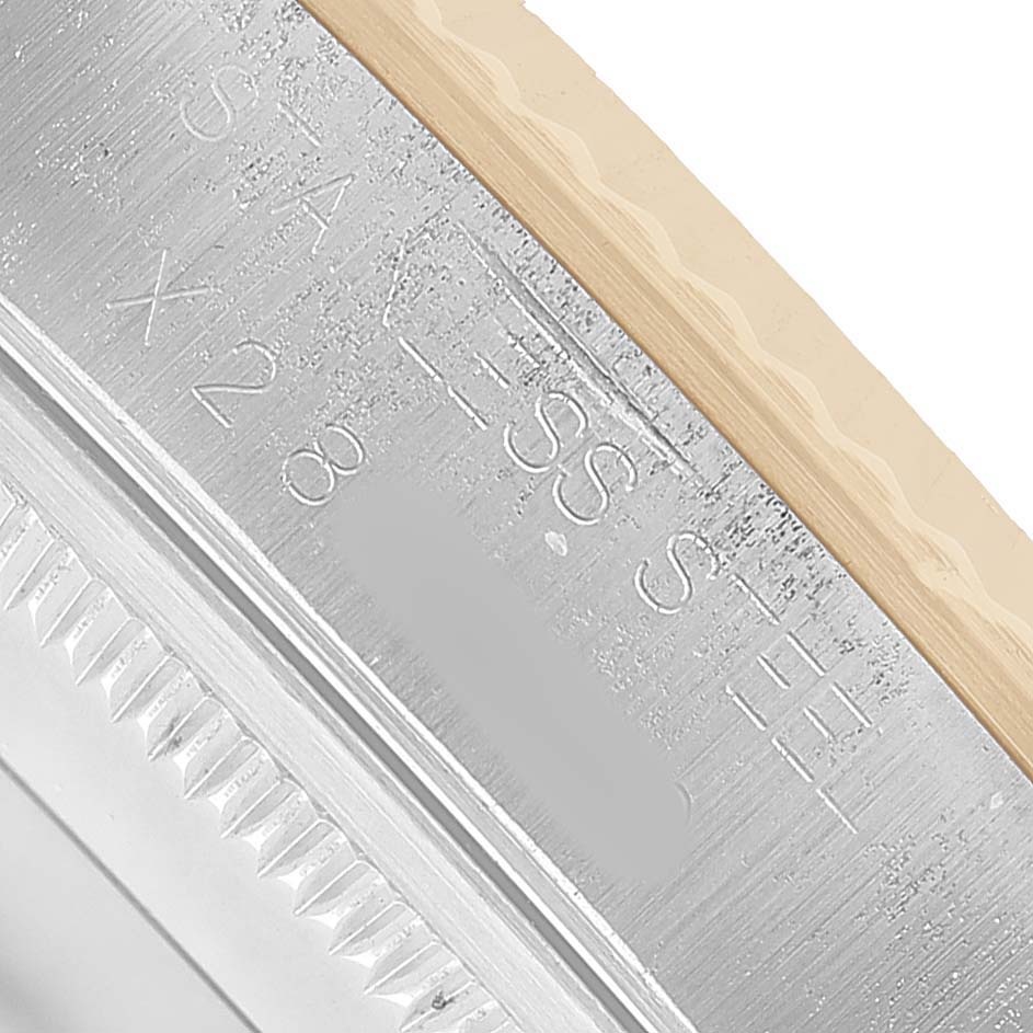 The image shows a close-up of the watch's edge and bezel with engravings on the Rolex Oyster Perpetual 14233 Men's Steel and Gold (two tone) Champagne Dial.