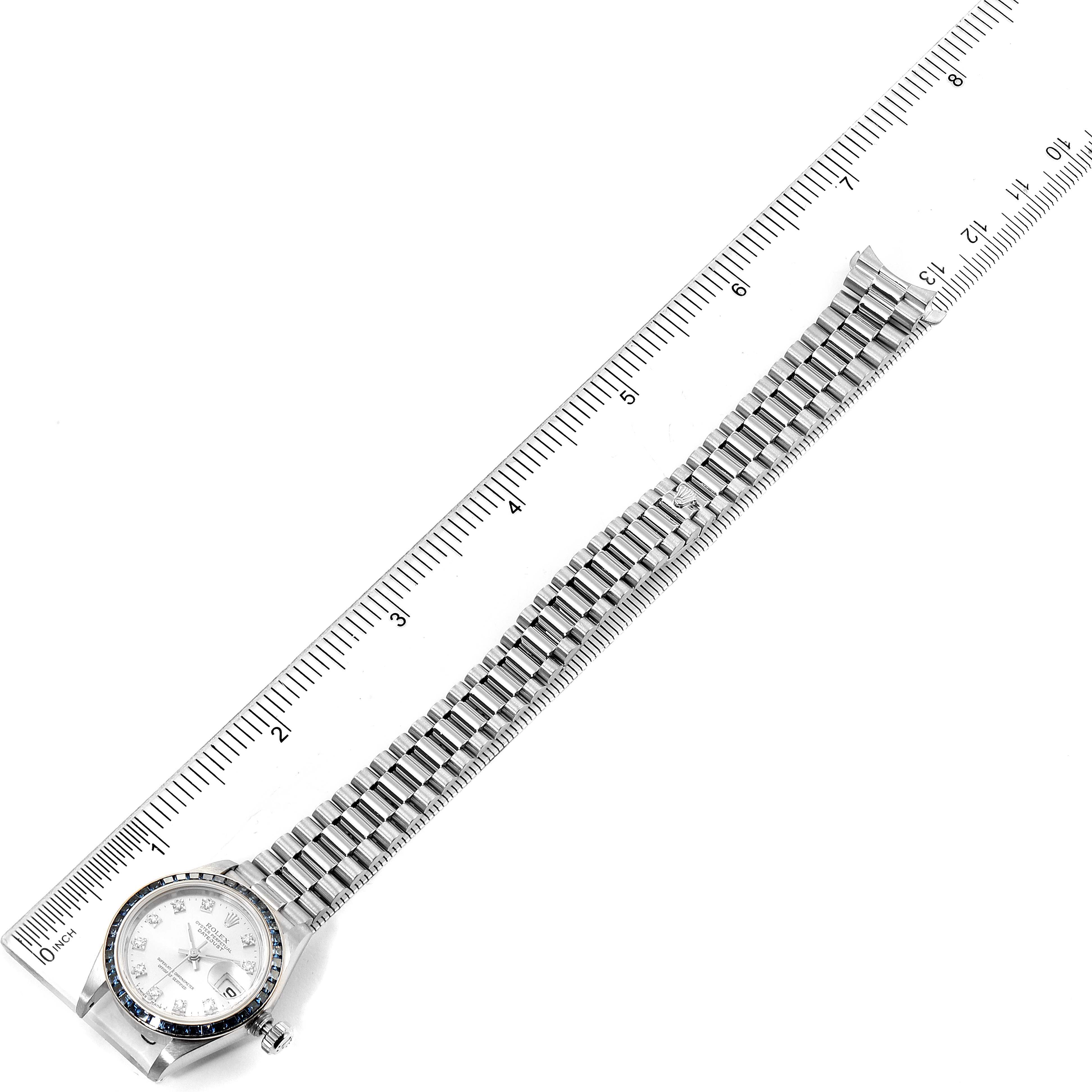 The image shows the top view of a Rolex President 69119 Women's White Gold Silver Dial 69119 Women's White Gold Silver Dial model watch, highlighting its face and bracelet, alongside a ruler for scale.