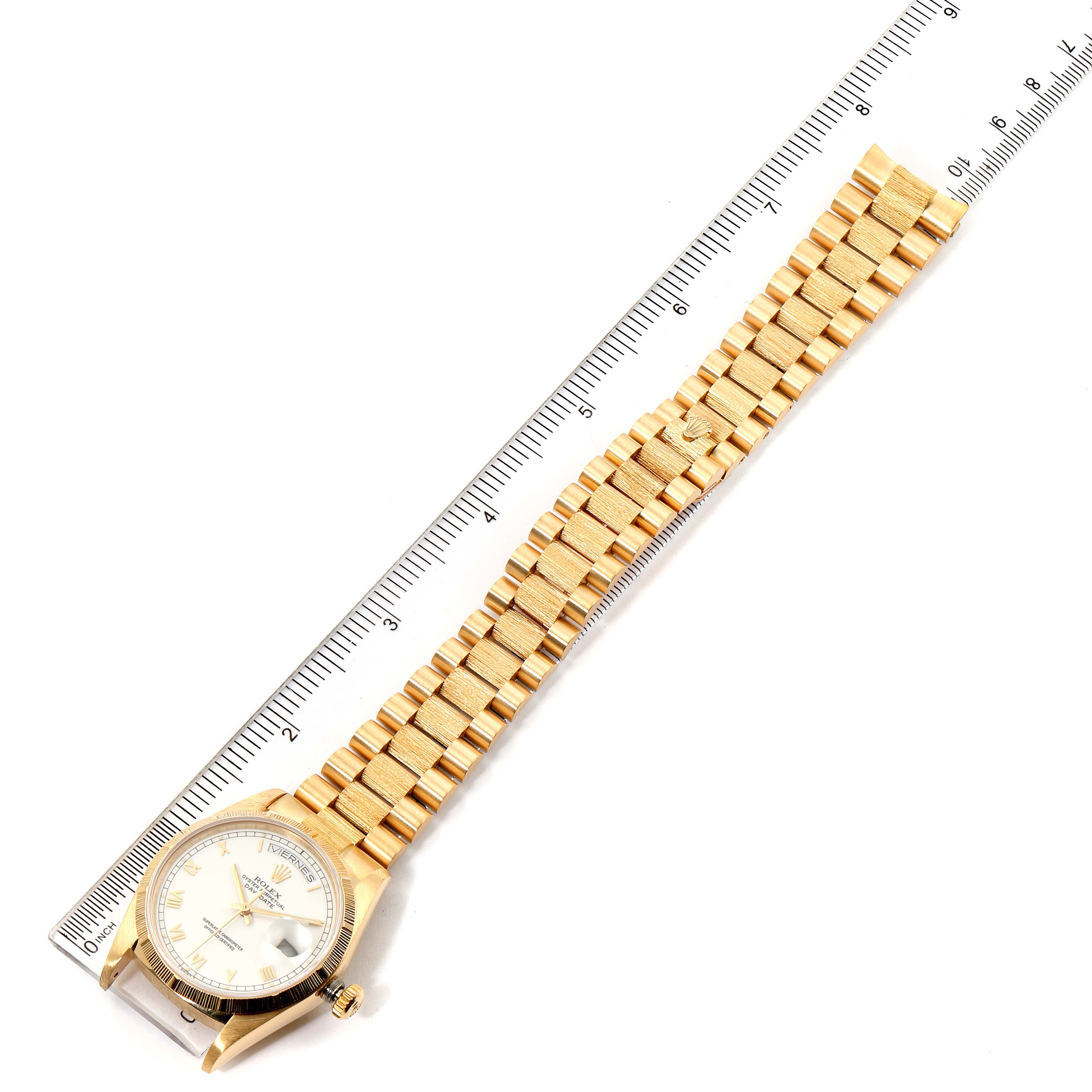 The image shows a Rolex President 18078 Men
s Yellow Gold White Dial 18078 Men
s Yellow Gold White Dial model watch laid flat with its full bracelet and part of a ruler for scale.
