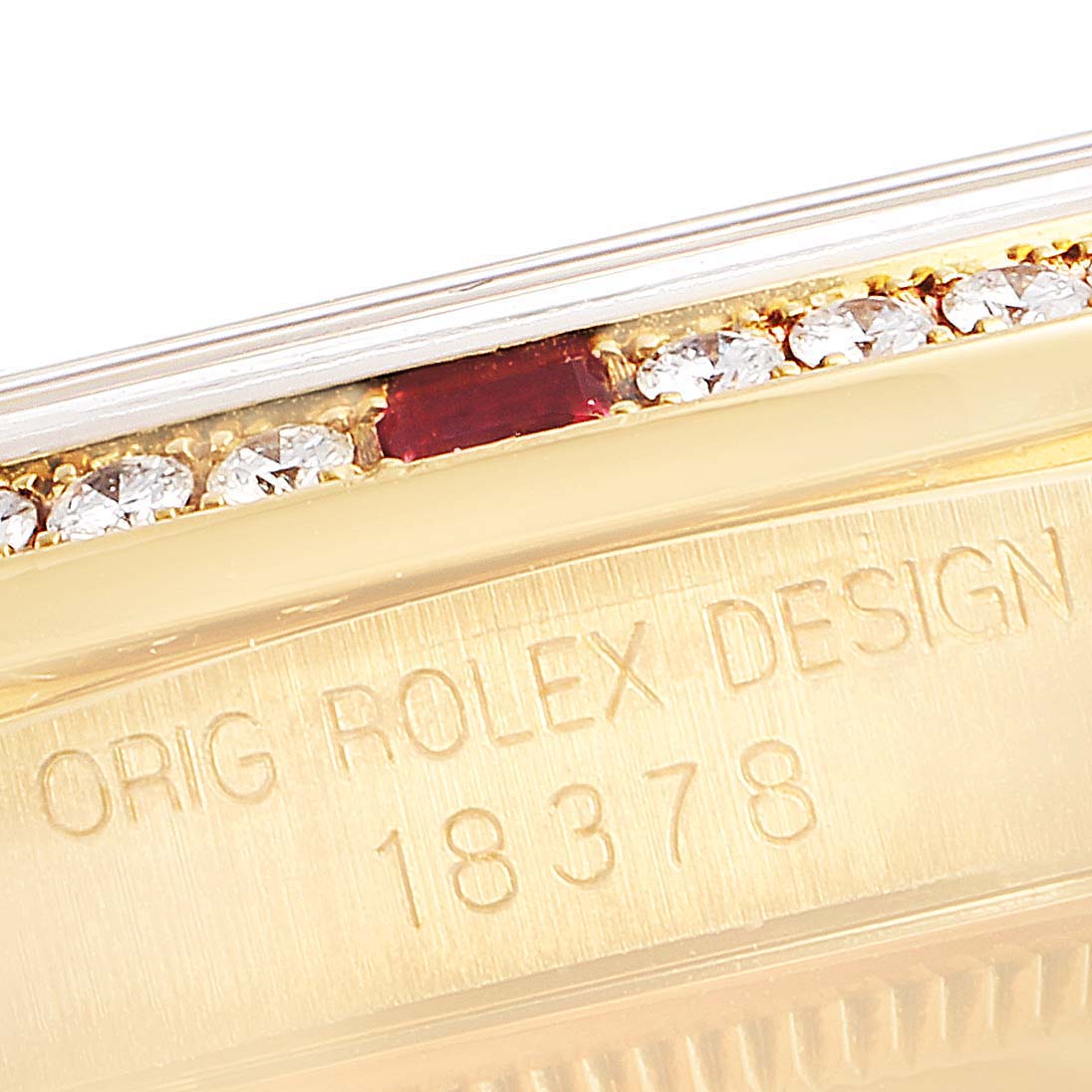 The image shows a close-up of the serial number and part of the bezel with diamonds and a ruby on a Rolex President 18378 Men's Yellow Gold Champagne Dial 18378 Men's Yellow Gold Champagne Dial model watch.