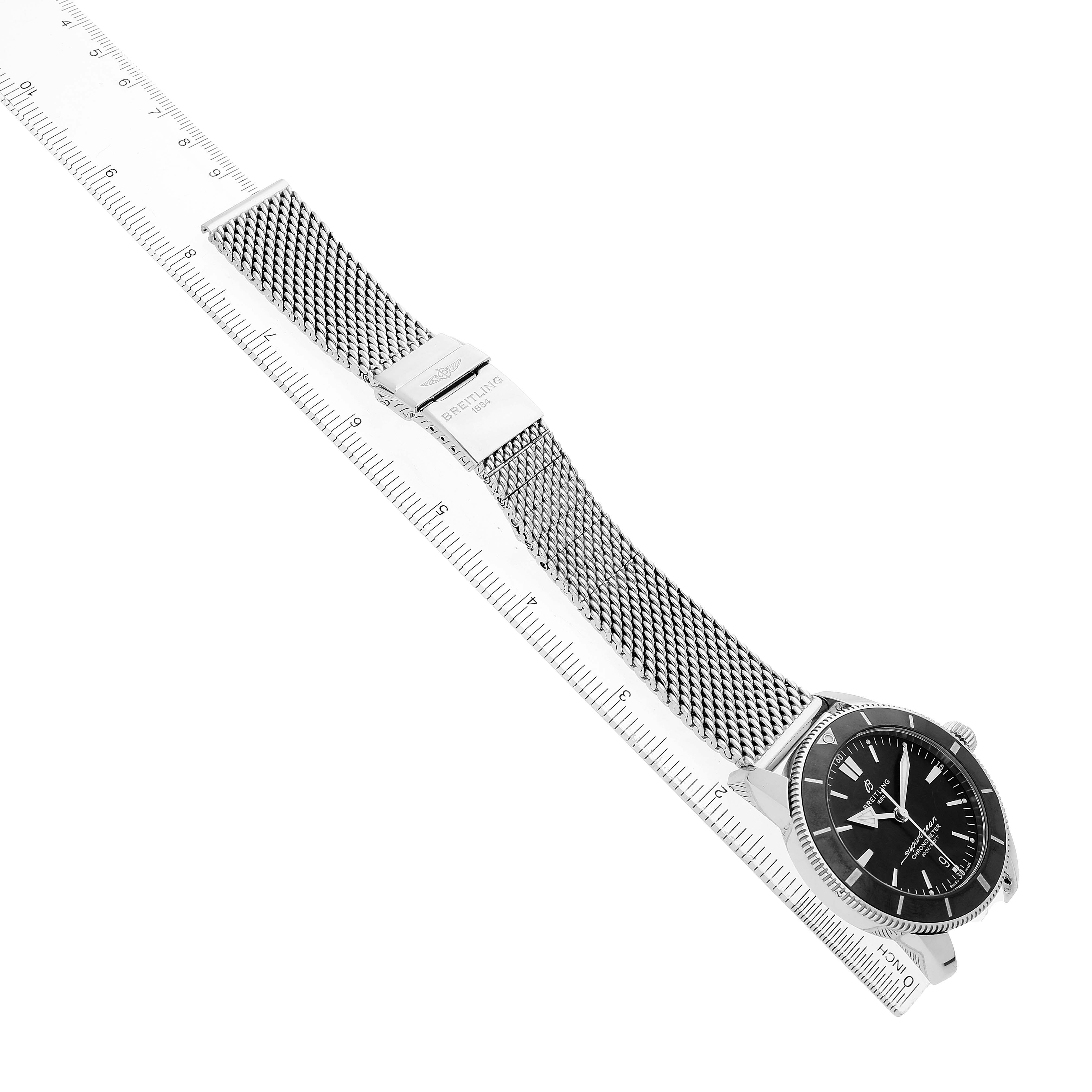 The image shows a Breitling Superocean AB2030 Men's Stainless Steel Black Dial watch at an angled top view, showcasing the face, mesh band, and clasp.