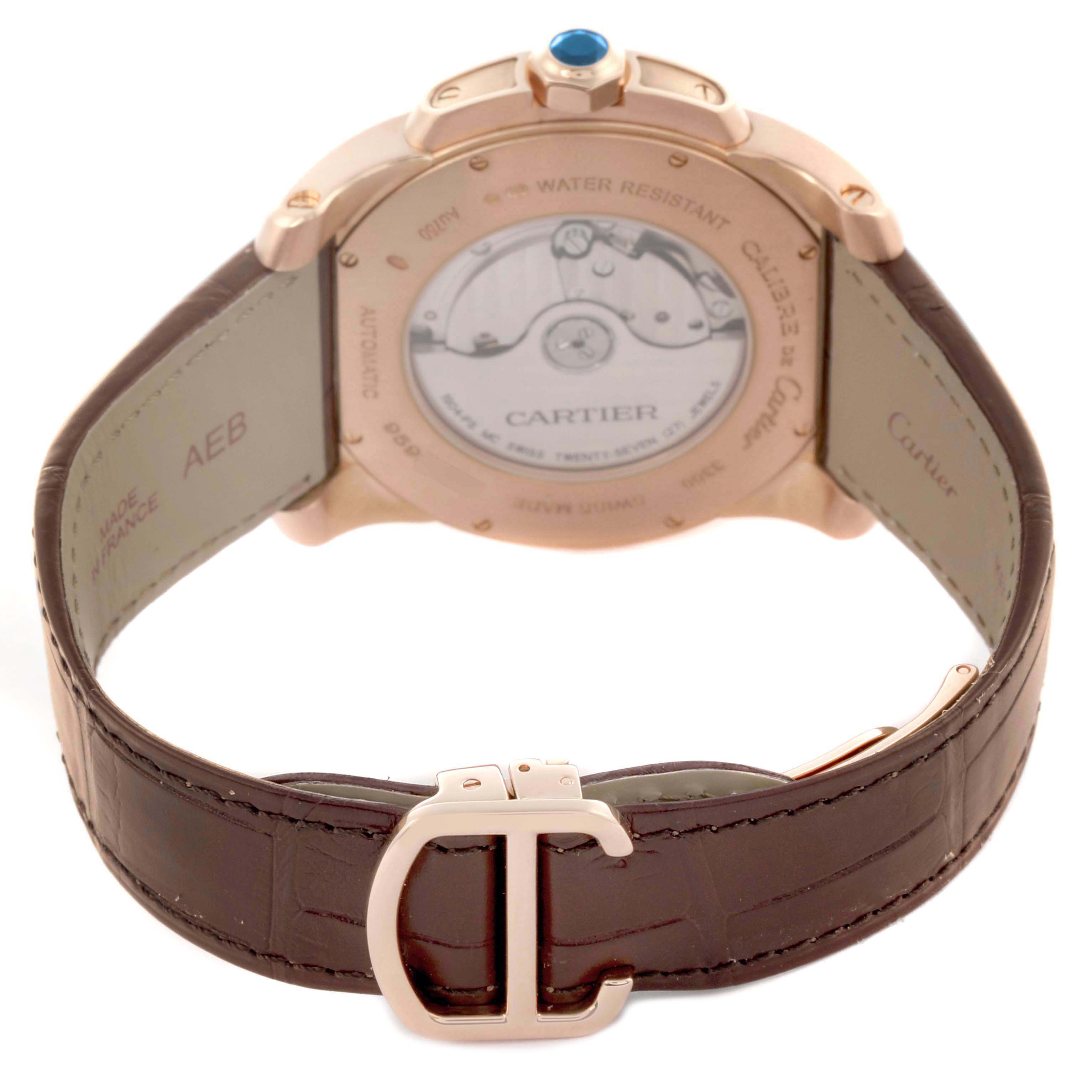 The Calibre de Cartier model W7100007 is shown from the rear, highlighting the exhibition case back, leather strap, and clasp with the Cartier logo.