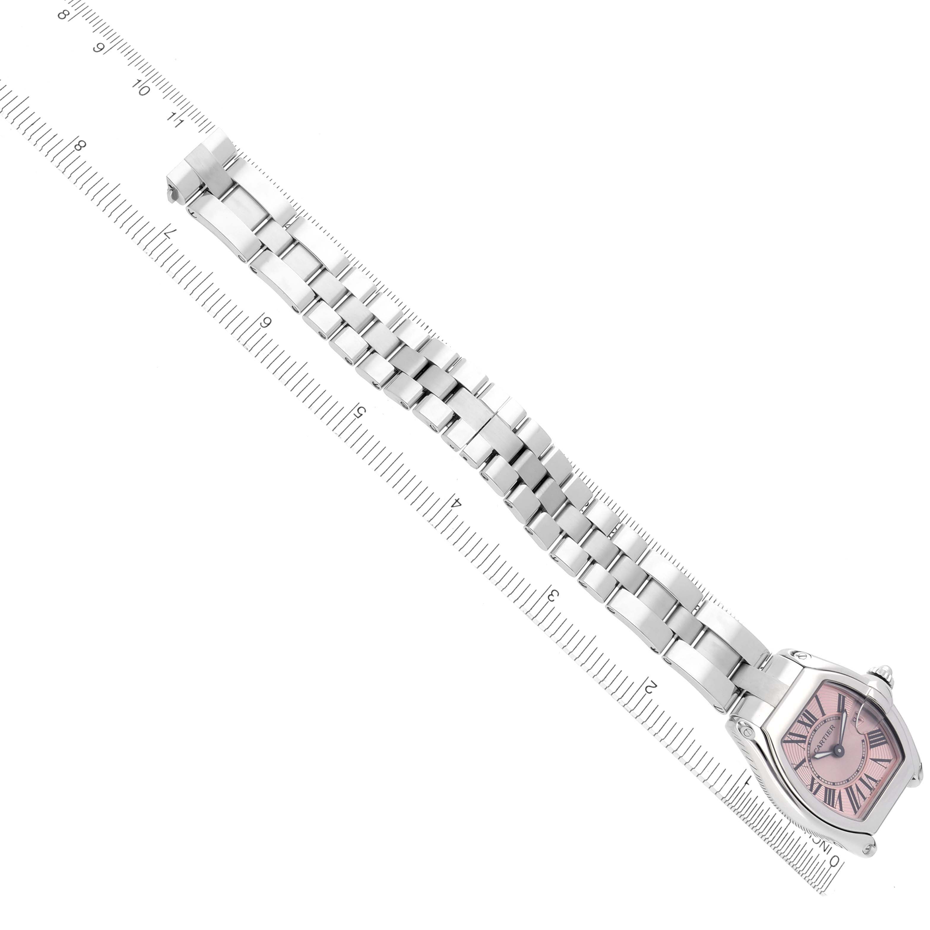 The Cartier Roadster W62017V3 Women's Stainless Steel Pink Dial W62017V3 Women's Stainless Steel Pink Dial watch is shown from an overhead angle, displaying the face, case, and metal bracelet aligned with a ruler.