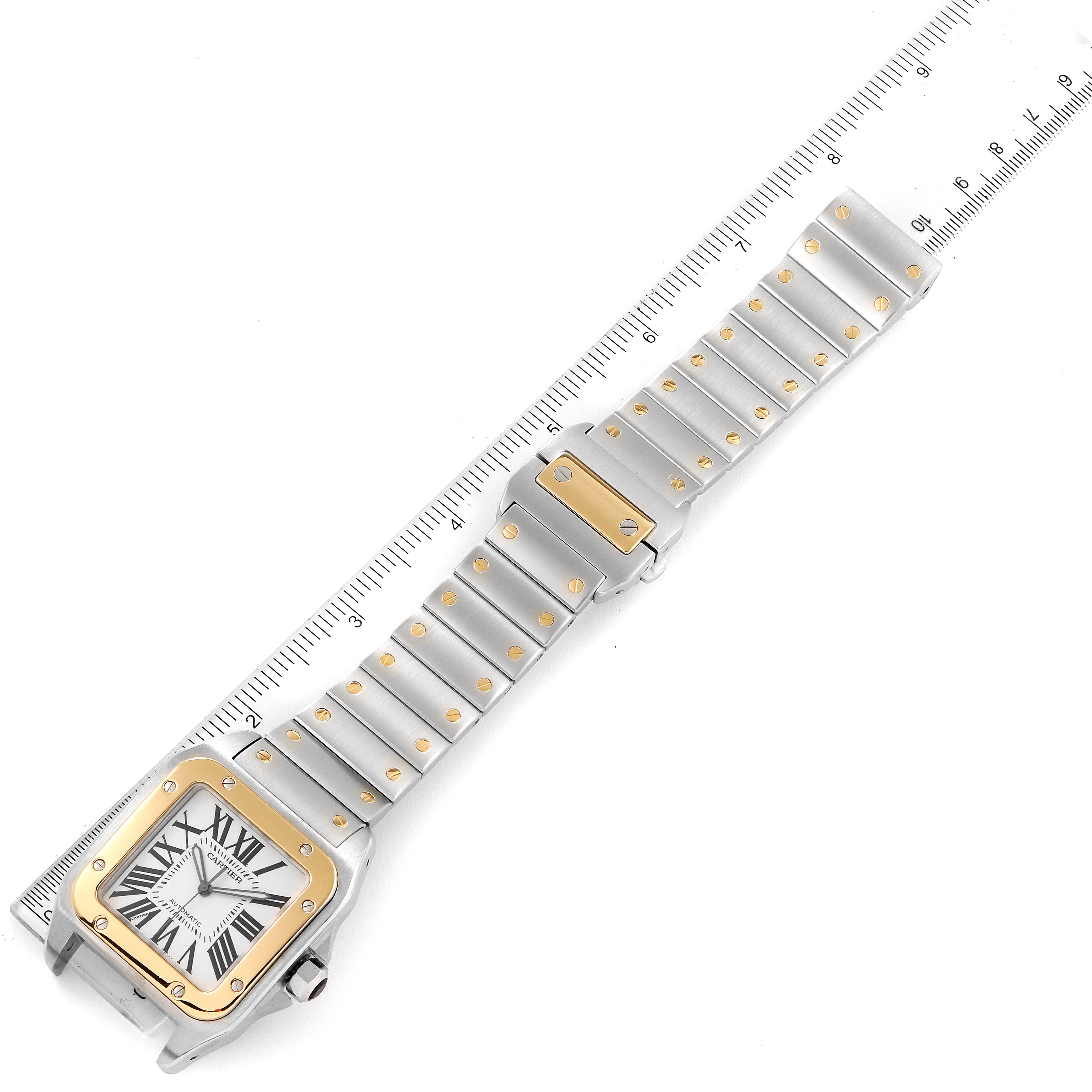 The Cartier Santos W200728G Men's Steel and Gold (two tone) Silver Dial W200728G Men's Steel and Gold (two tone) Silver Dial watch is shown from a top-down angle, displaying the face, bezel, and full bracelet with a ruler for scale.