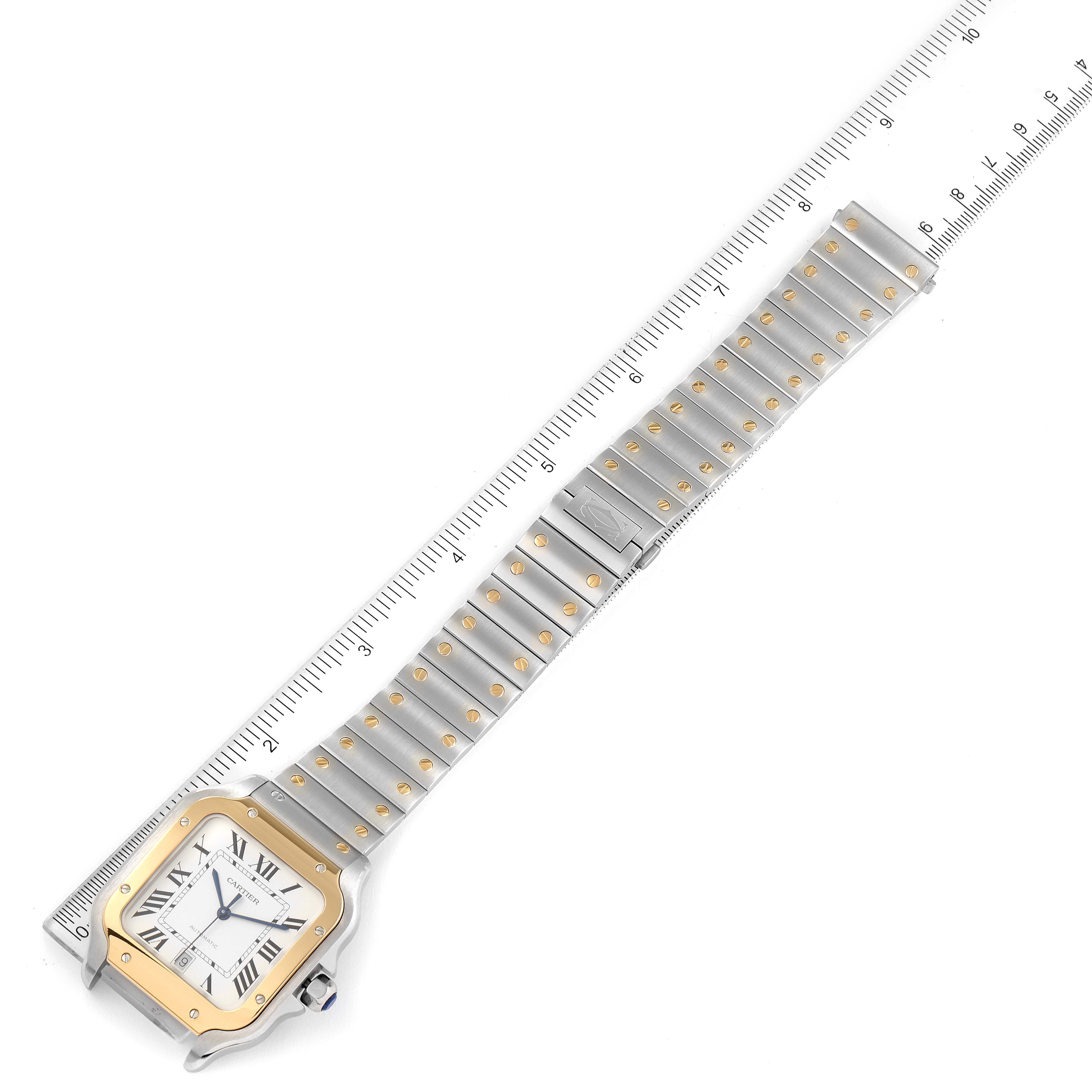 The Cartier Santos W2SA0009 Men's Steel and Gold (two tone) Silver Dial W2SA0009 Men's Steel and Gold (two tone) Silver Dial watch is shown from a top view, displaying the face, case, and full metal bracelet against a ruler for size reference.