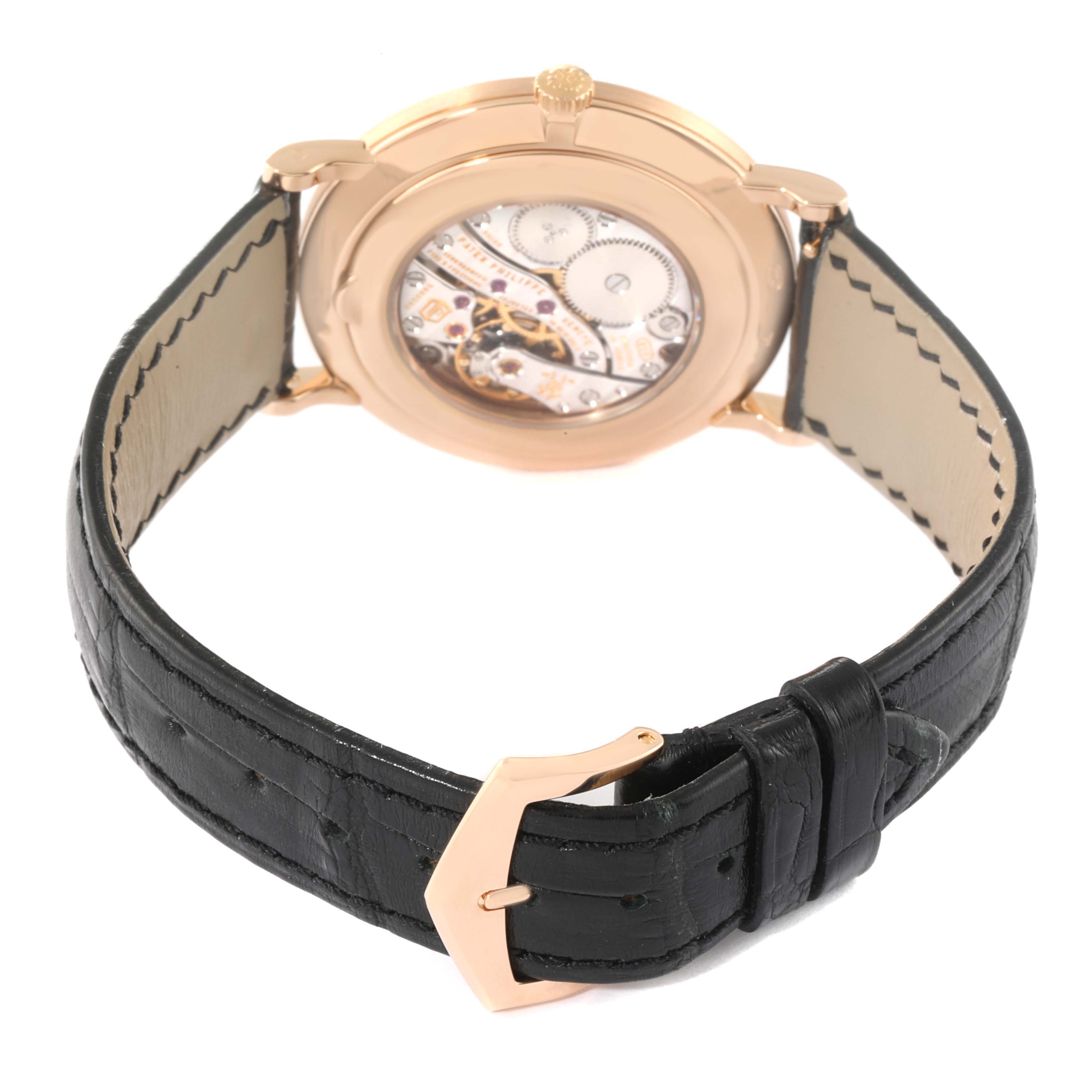 The image shows the back view of a Patek Philippe Calatrava 5119R Men
s Rose Gold White Dial 5119R Men
s Rose Gold White Dial watch, highlighting its movement and black leather strap.