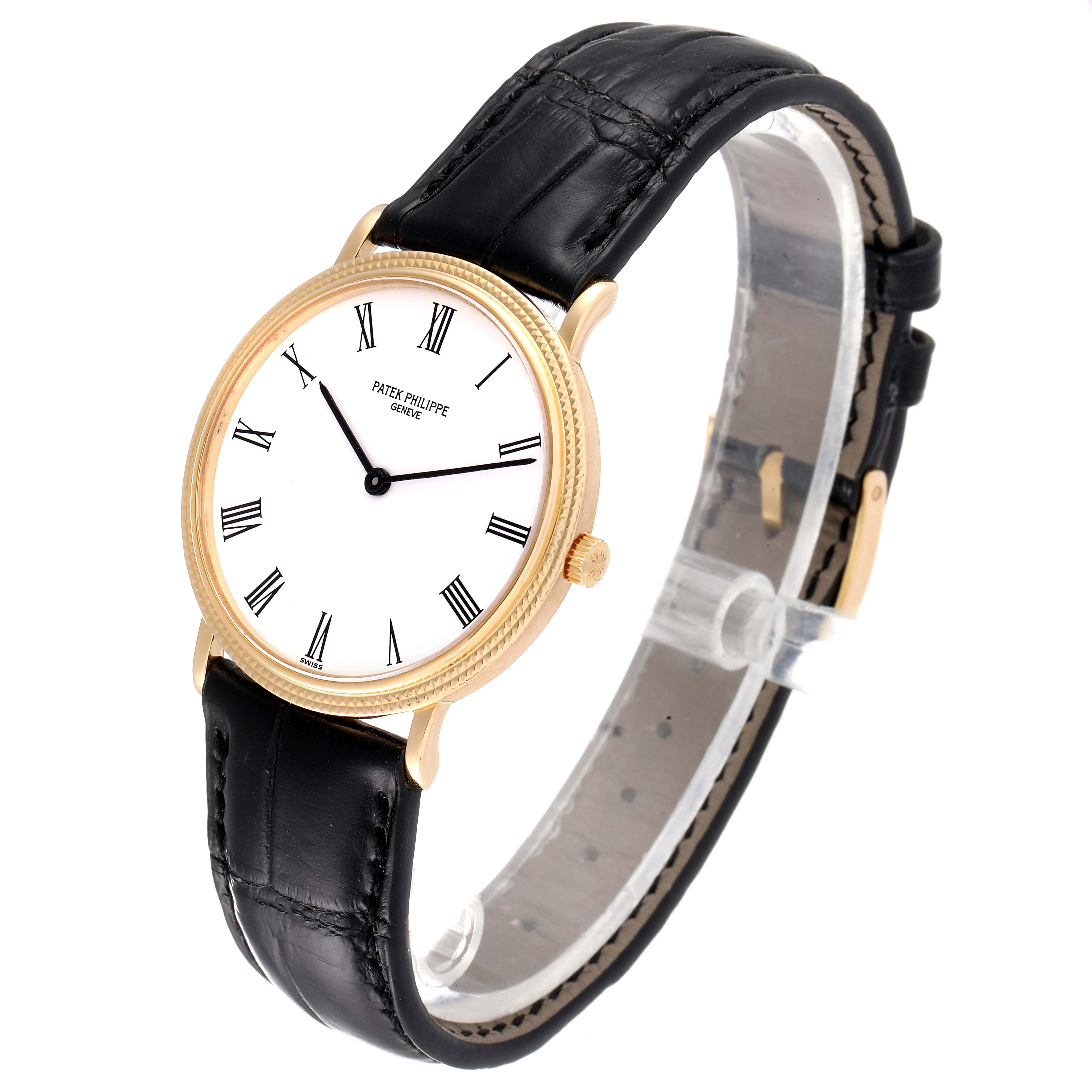 This image shows a Calatrava model by Patek Philippe from a front angle, highlighting its gold case, white dial, and black leather strap.