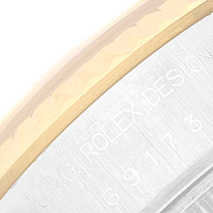 The image shows a close-up of the side of the Rolex Datejust 69173 Women's Steel and Gold (two tone) White Dial 69173 Women's Steel and Gold (two tone) White Dial watch, highlighting the bezel and engraved text on the case.