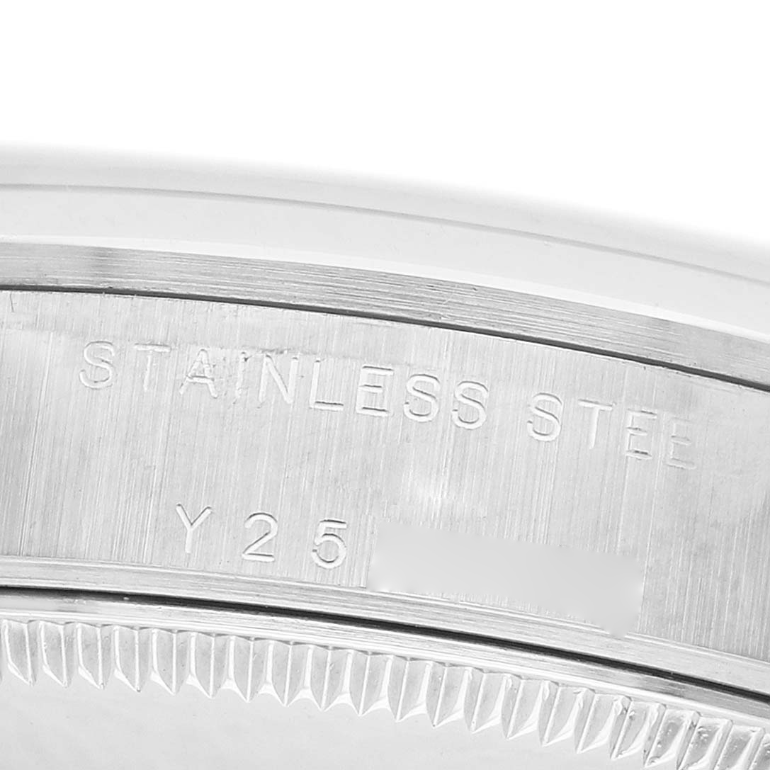 The image shows a close-up of the side with engravings on the caseback of a mid-size Rolex watch, highlighting "STAINLESS STEEL" text.