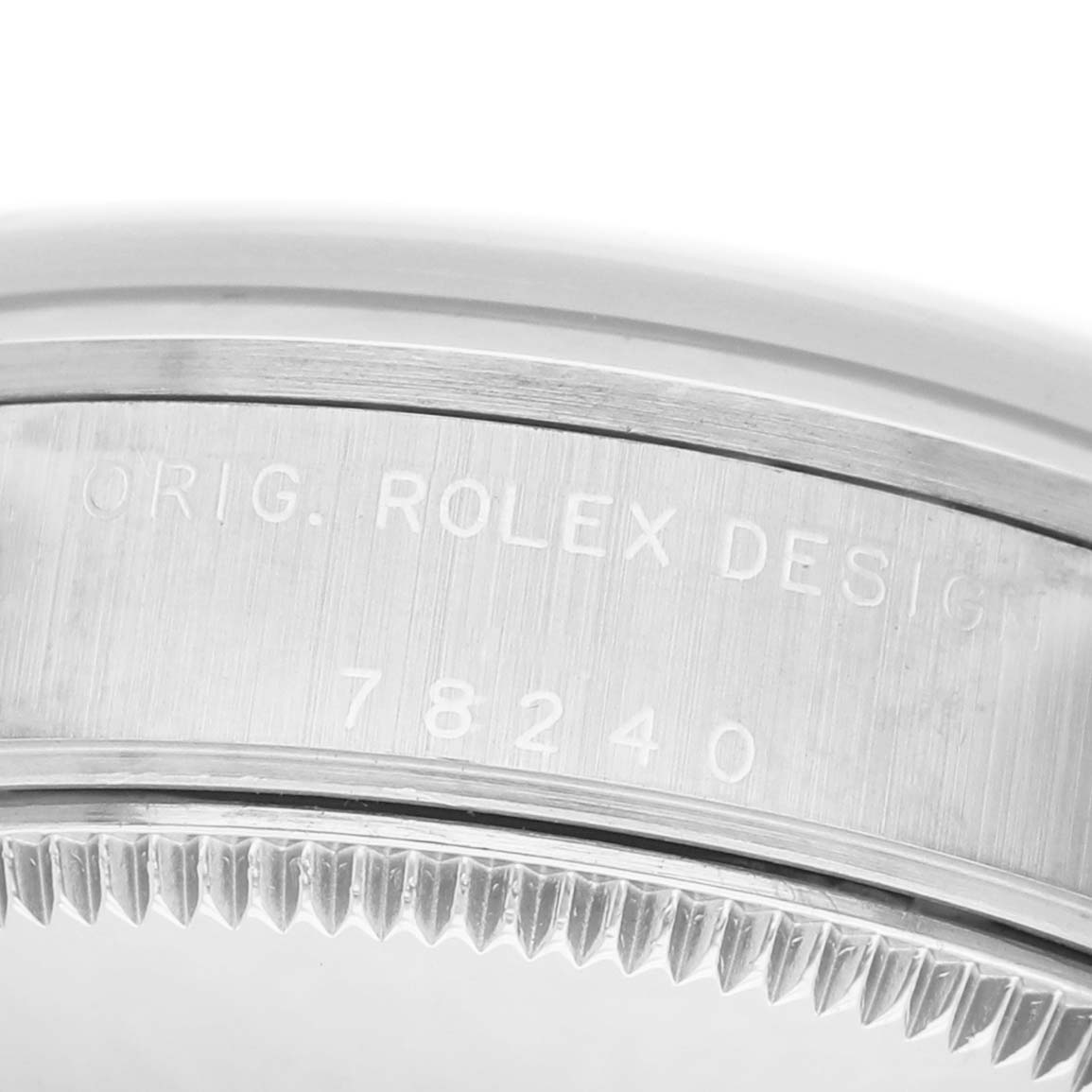 The image shows the side view of a Rolex Mid-Size 78240 Women's Stainless Steel White Dial model focusing on the engraved bezel.