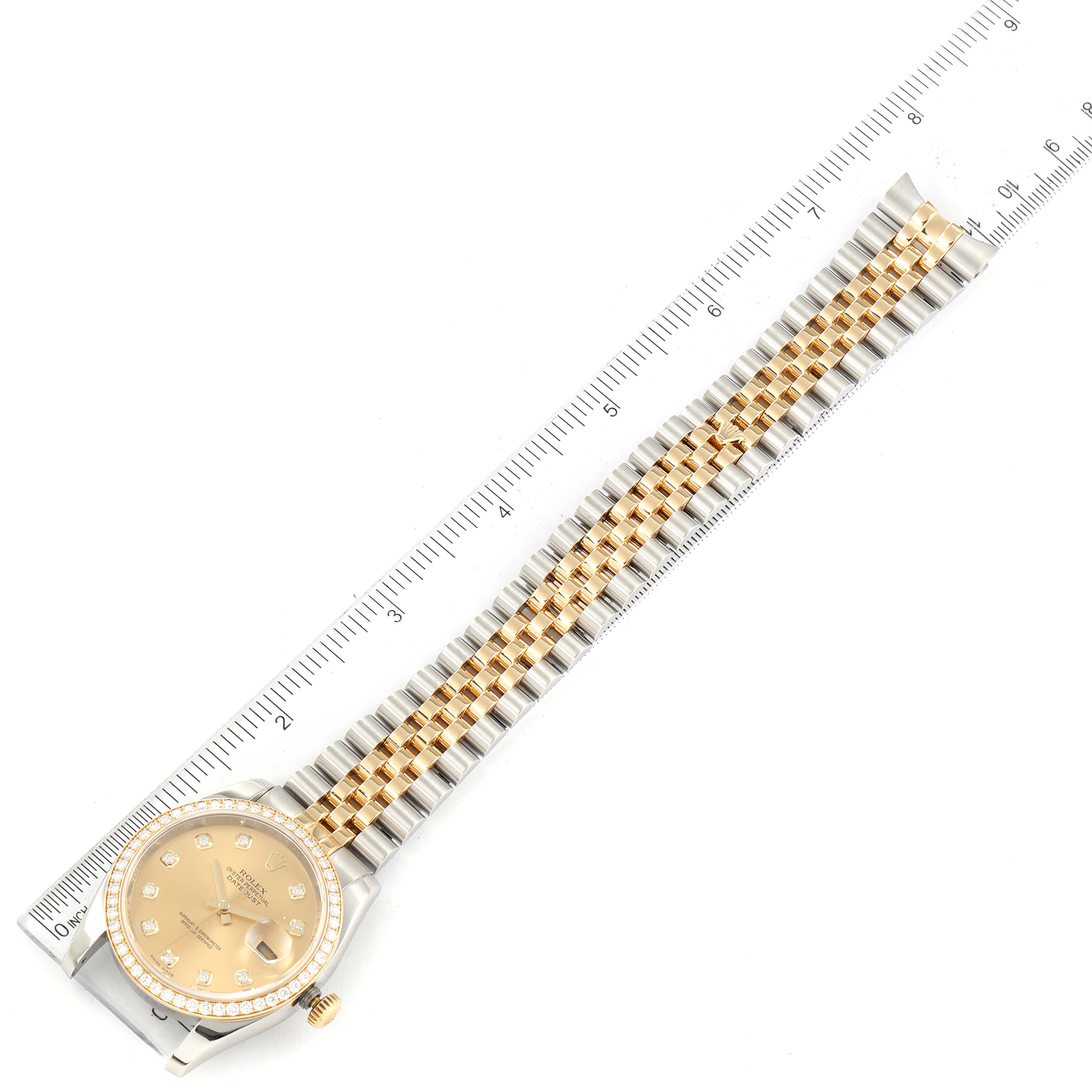 The image shows the Rolex Datejust 116243 Men
s Steel and Gold (two tone) Champagne Dial 116243 Men
s Steel and Gold (two tone) Champagne Dial watch laid flat with its bracelet extended, placed next to a ruler for scale.
