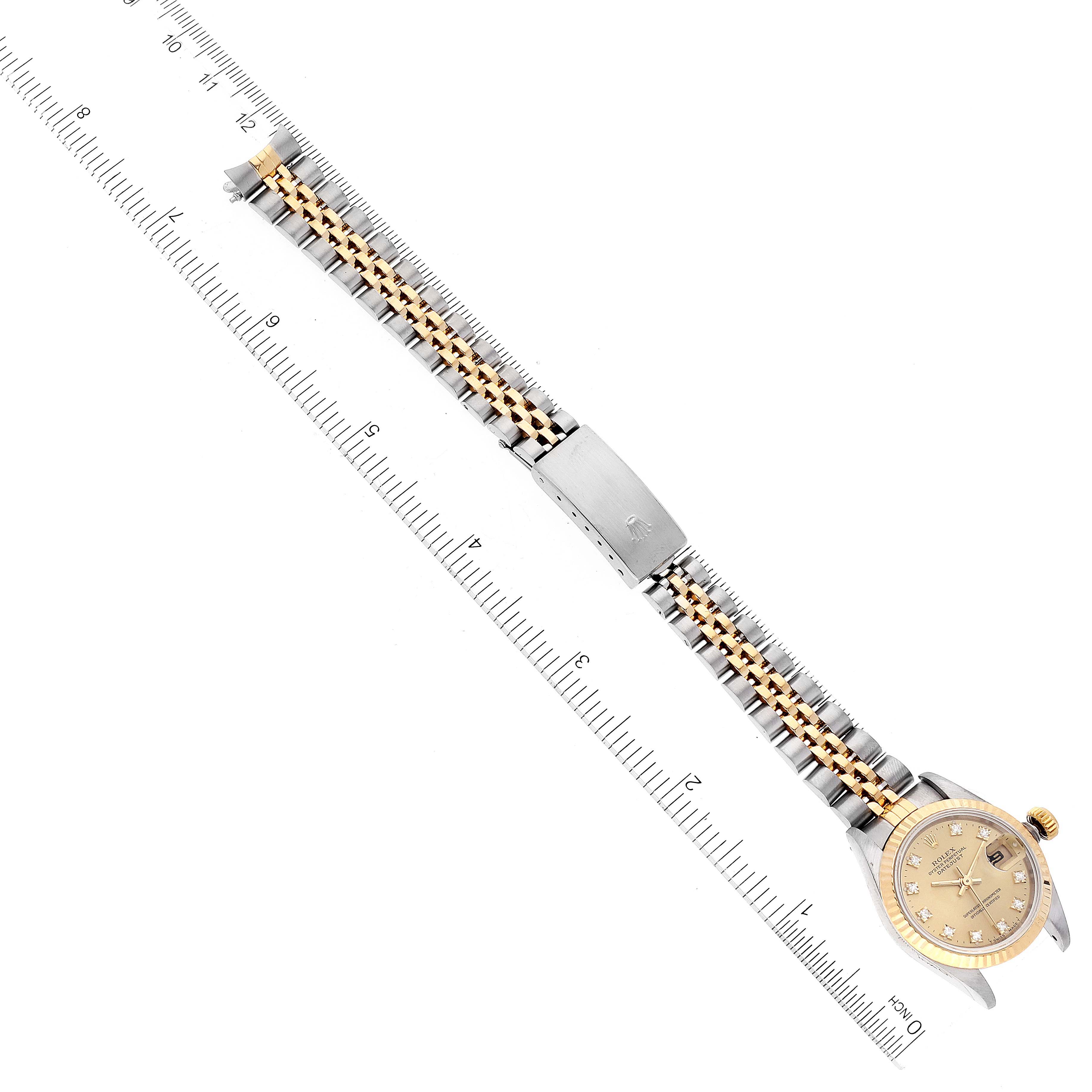 This image shows a laid-out Rolex Datejust 69173 Women's Steel and Gold (two tone) Champagne Dial 69173 Women's Steel and Gold (two tone) Champagne Dial watch with its dial, bezel, bracelet, and clasp visible, alongside a ruler for scale.