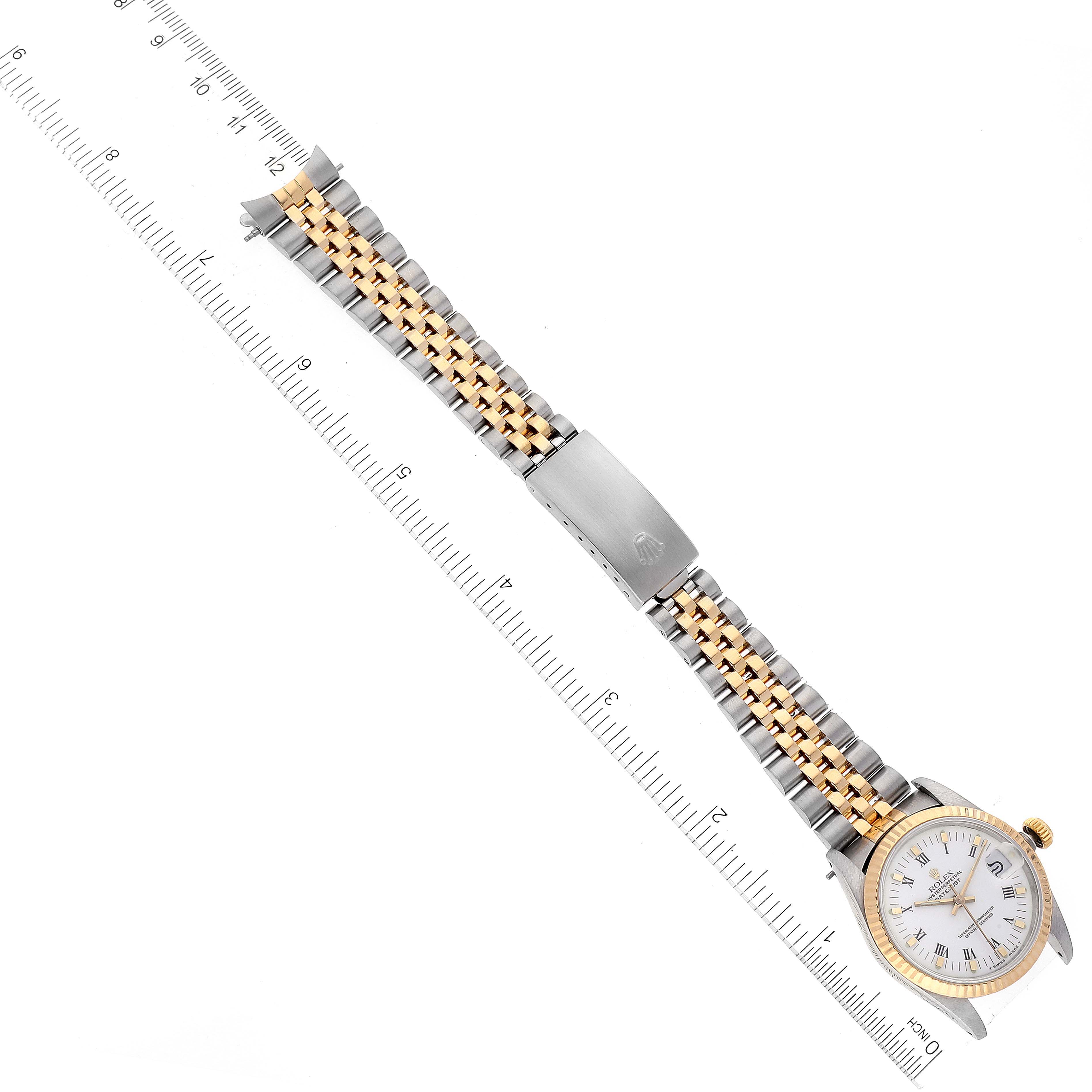 This image shows the front view of a Rolex Mid-Size 68273 Women's Steel and Gold (two tone) White Dial 68273 Women's Steel and Gold (two tone) White Dial model watch, displaying the face, bezel, and the entire bracelet alongside a ruler.