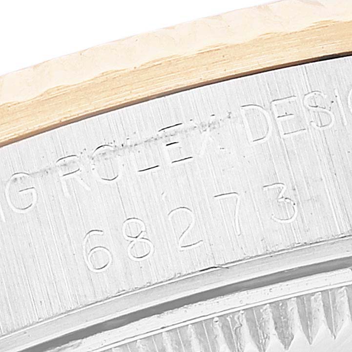 A close-up of the serial number and "ROLEX DESIGN" engraving on the case side of a Rolex Mid-Size 68273 Women's Steel and Gold (two tone) White Dial 68273 Women's Steel and Gold (two tone) White Dial model watch.