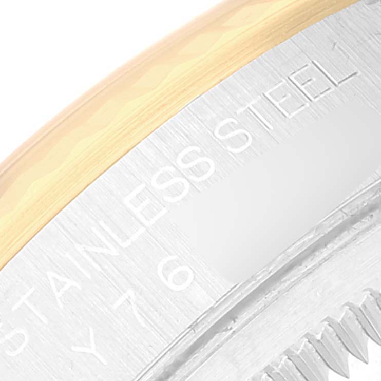 This close-up image of the Rolex Datejust 16233 Men's Steel and Gold (two tone) Champagne Dial 16233 Men's Steel and Gold (two tone) Champagne Dial model shows part of the bezel and case back with "STAINLESS STEEL" engraved.