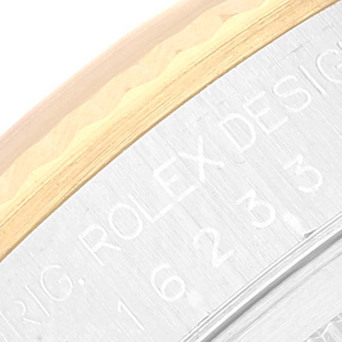The image shows a close-up of the side of the Rolex Datejust 16233 Men's Steel and Gold (two tone) Champagne Dial 16233 Men's Steel and Gold (two tone) Champagne Dial watch, highlighting the edge of the bezel and part of the case with engraved text.