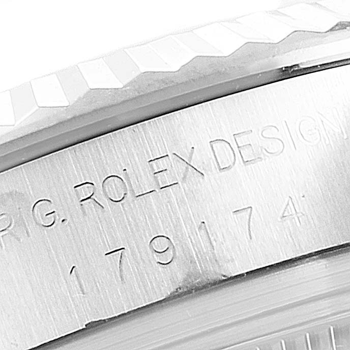 The image shows a close-up angle of the Rolex Datejust 179174 Women
s Stainless Steel Mother of Pearl Dial 179174 Women
s Stainless Steel Mother of Pearl Dial model watch bezel and engraved serial number on the watch case.