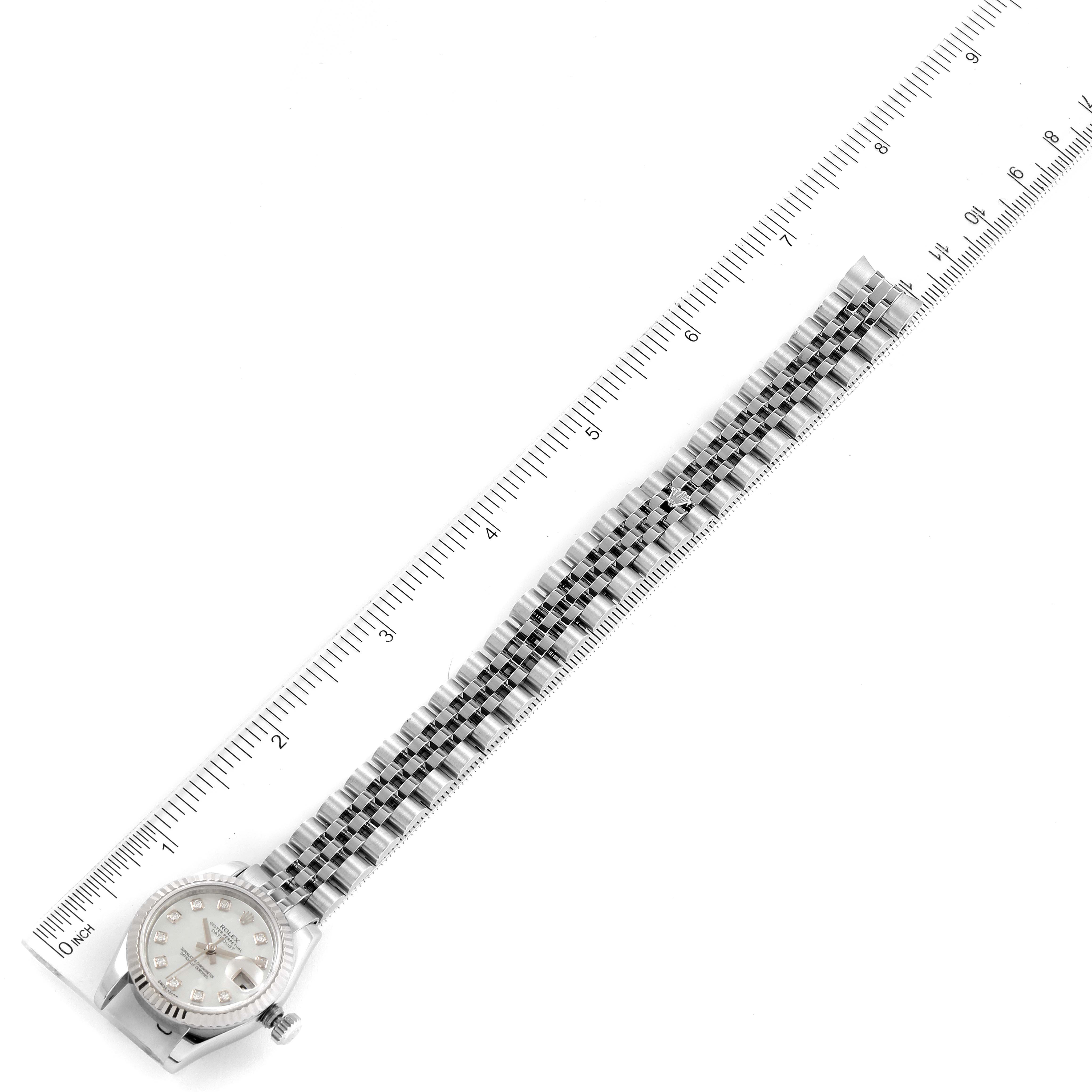 The Rolex Datejust 179174 Women
s Stainless Steel Mother of Pearl Dial 179174 Women
s Stainless Steel Mother of Pearl Dial watch is shown flat with its face and full bracelet alongside a ruler for size reference.