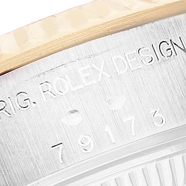 This close-up image shows a portion of the case side and the engraved text on the Rolex Datejust 79173 Women's Steel and Gold (two tone) Champagne Dial 79173 Women's Steel and Gold (two tone) Champagne Dial model's stainless steel case.