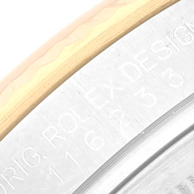 This close-up image shows the engraved markings on the bezel of a Rolex Datejust 116233 Men's Steel and Gold (two tone) White Dial 116233 Men's Steel and Gold (two tone) White Dial watch.