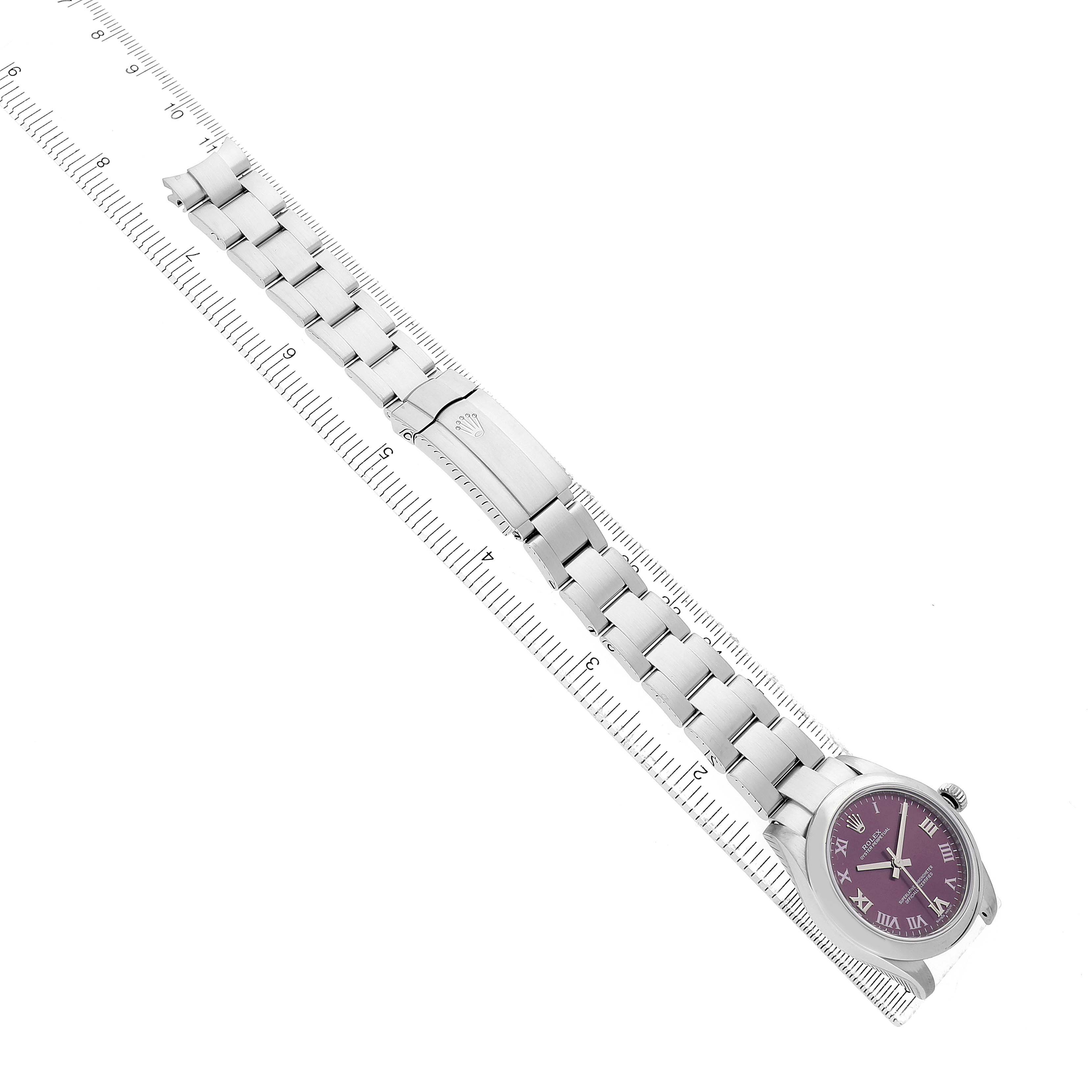 The image shows a Rolex Mid-Size 177200 Women's Stainless Steel Purple Dial watch laid flat with a metal bracelet, next to a ruler for scale.