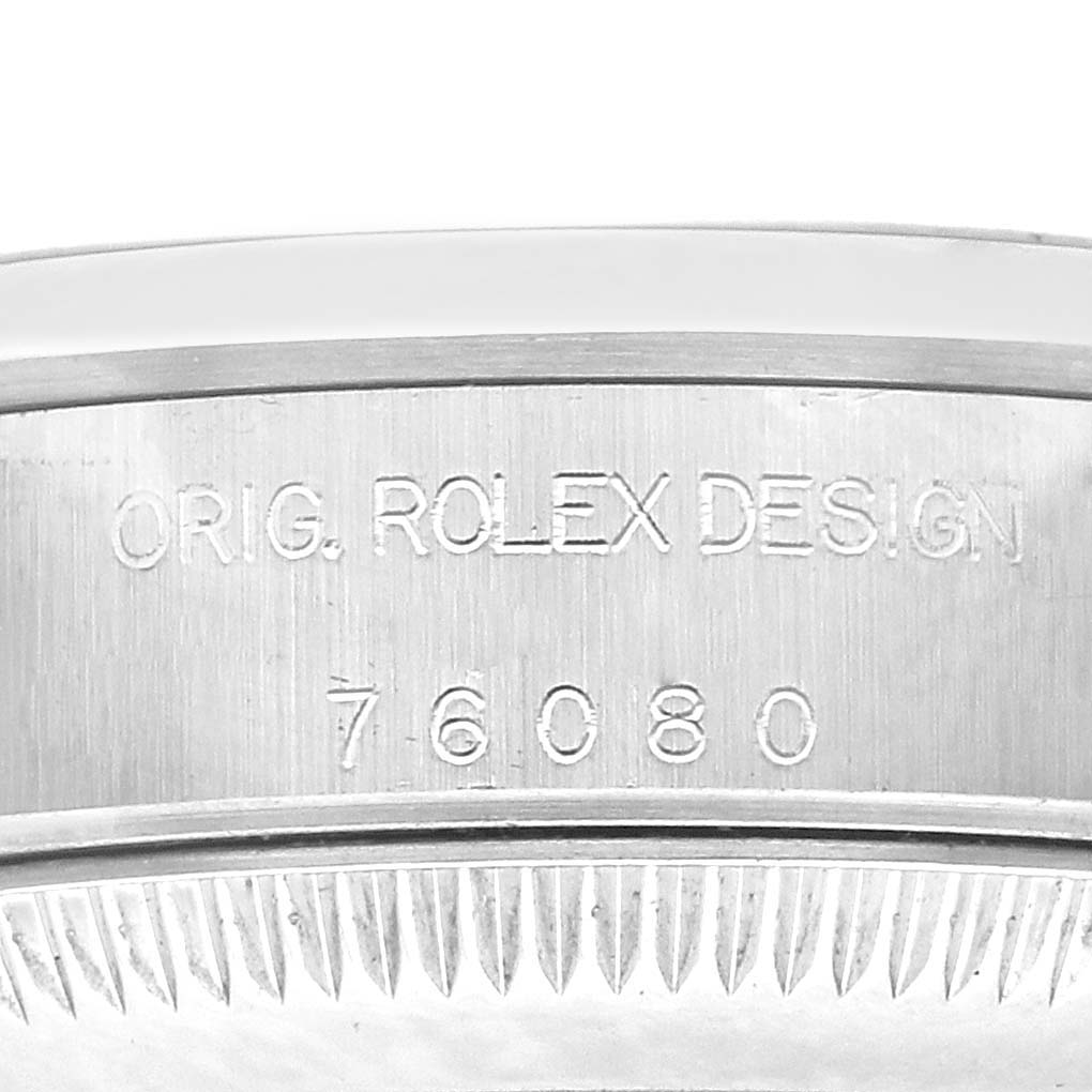 The image shows a close-up of the case side from a Rolex Oyster Perpetual 76080 Women's Stainless Steel Orange Dial 76080 Women's Stainless Steel Orange Dial, highlighting the engraved "Orig. Rolex Design" and serial number.