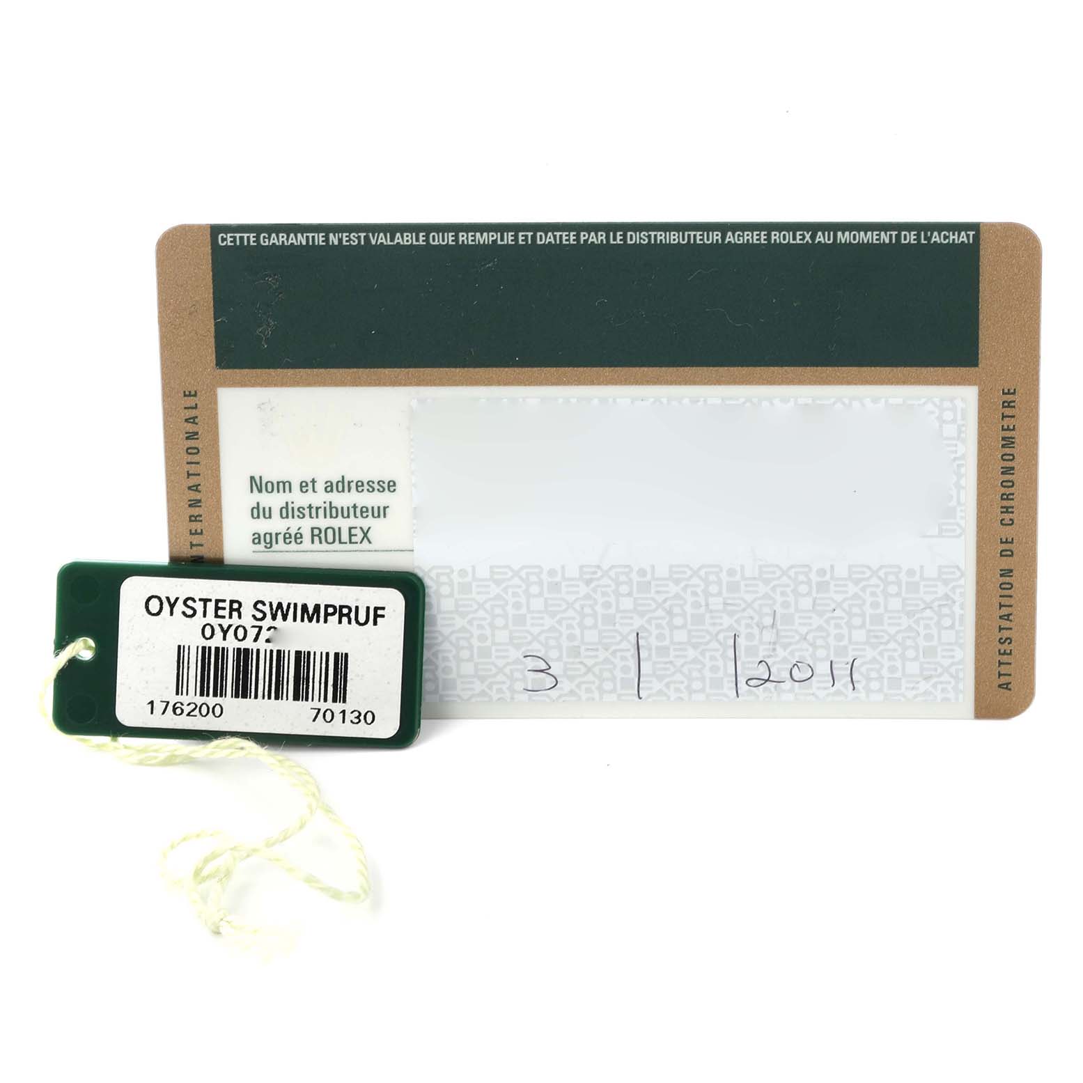 The image shows an Oyster Perpetual model warranty card and a green Rolex tag with serial information.