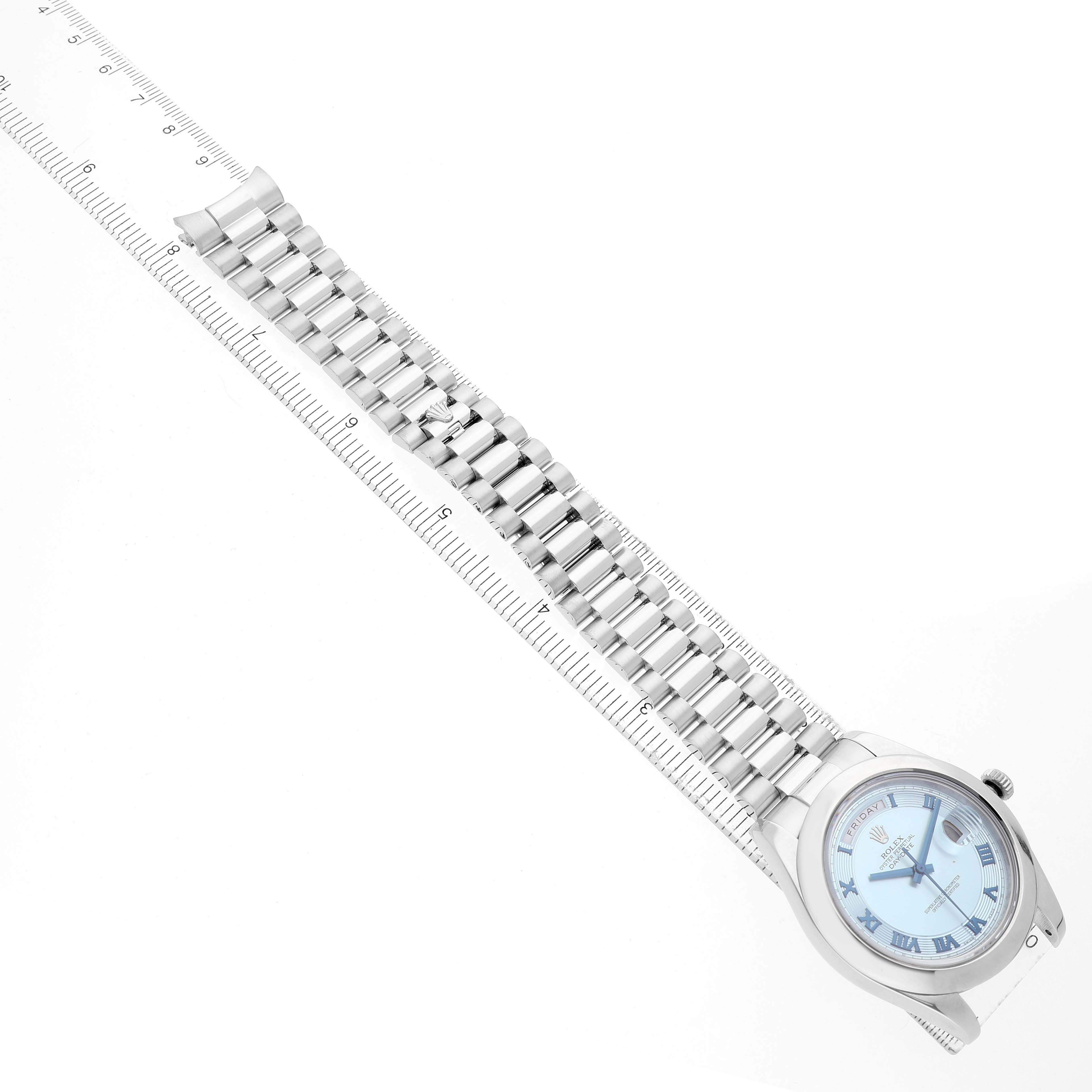 The Rolex President 218206 Men's Platinum Blue Dial model watch is shown from a top-down angle, featuring the full face, bezel, and bracelet against a ruler.
