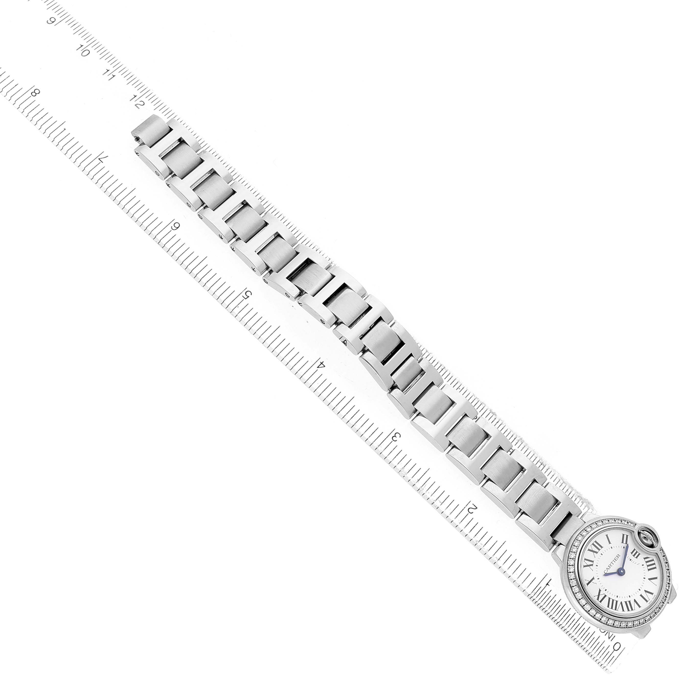 The Cartier Ballon Bleu W4BB0015 Women's Stainless Steel Silver Dial watch is displayed at an angle, highlighting the bracelet and face, with a ruler for scale.