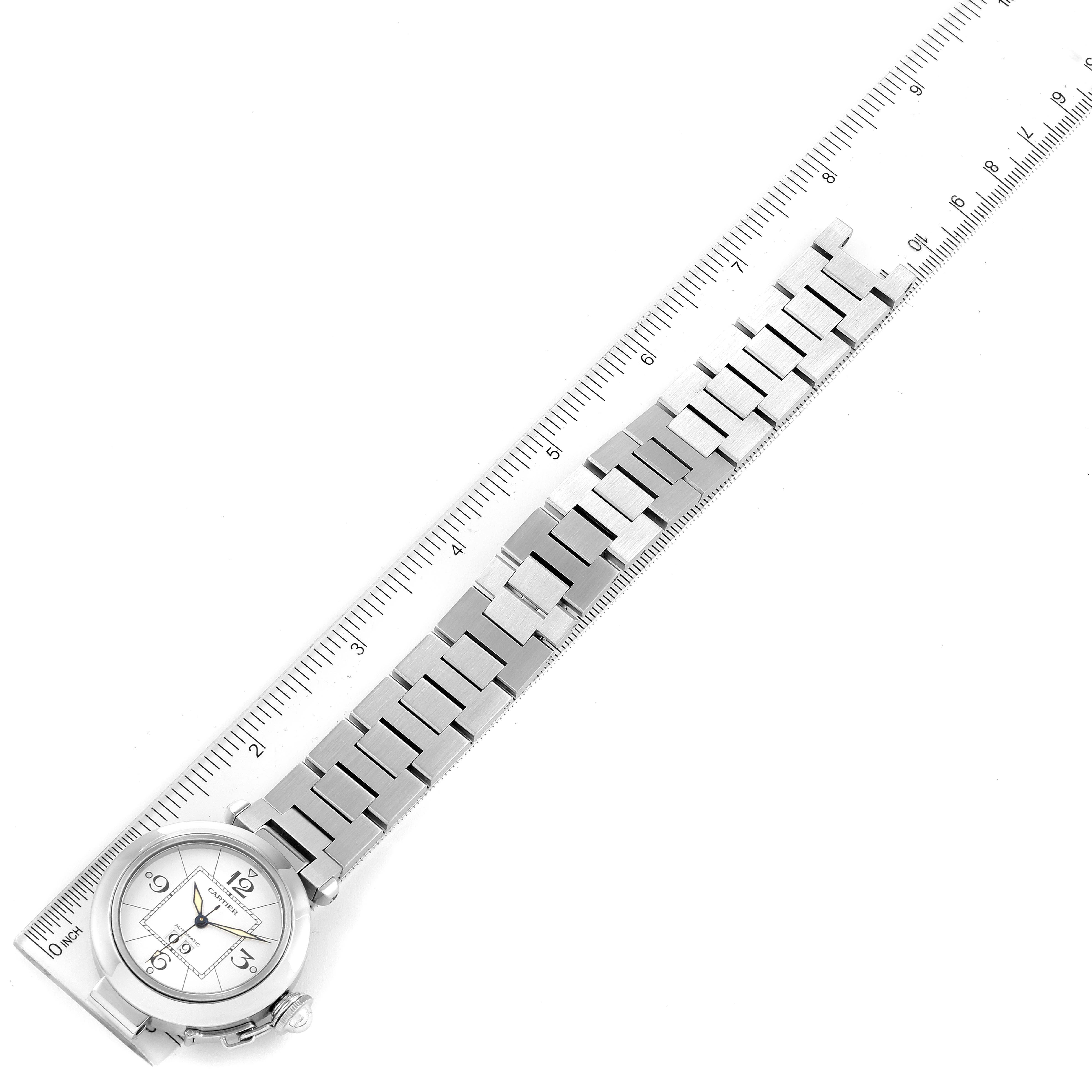 The image shows a Cartier Pasha W31055M7 Men's Stainless Steel White Dial W31055M7 Men's Stainless Steel White Dial watch laid flat with a metal bracelet and a ruler for measuring its length.