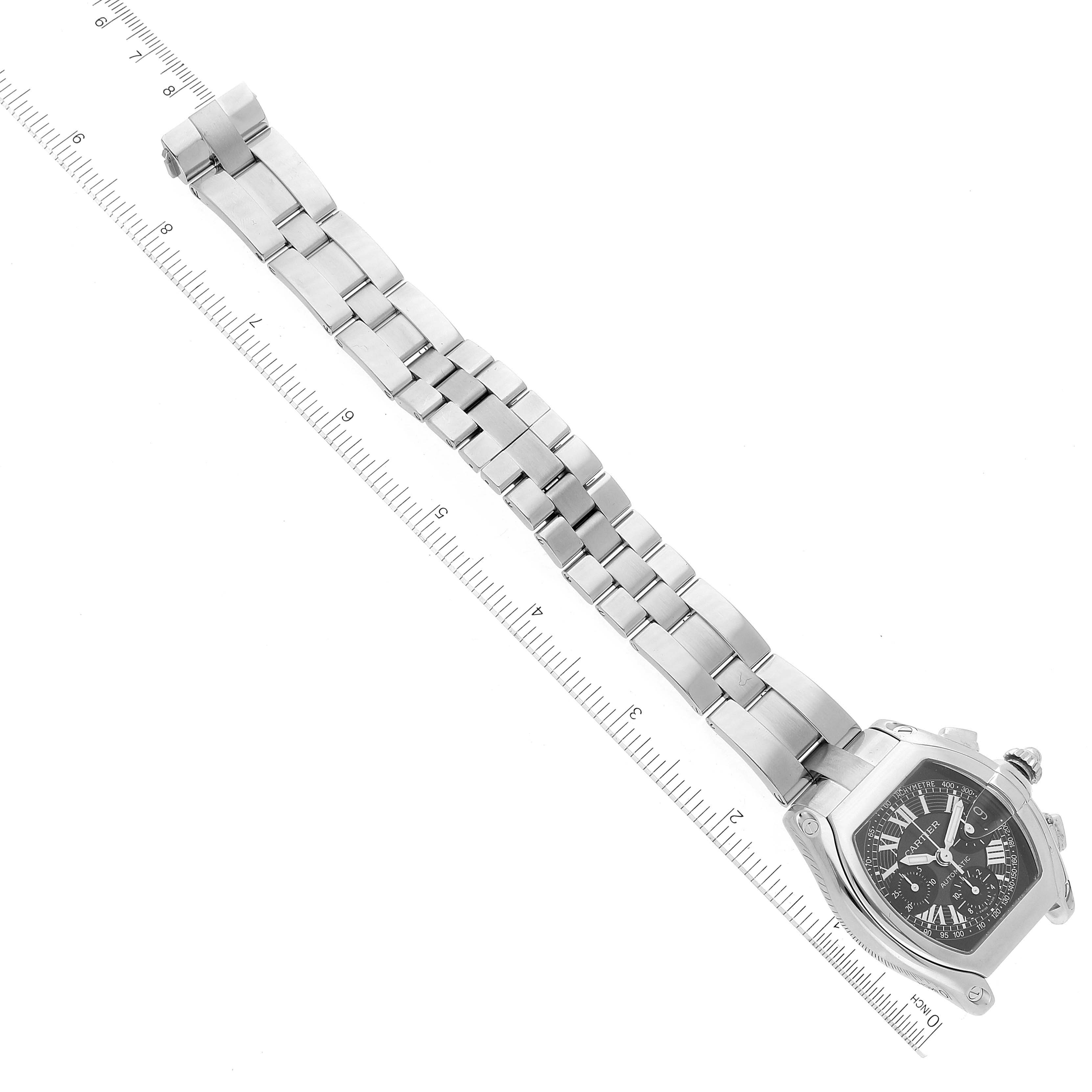 The image shows a Cartier Roadster W62007X6 Men's Stainless Steel Black Dial W62007X6 Men's Stainless Steel Black Dial watch laid flat with its band alongside a ruler for scale.