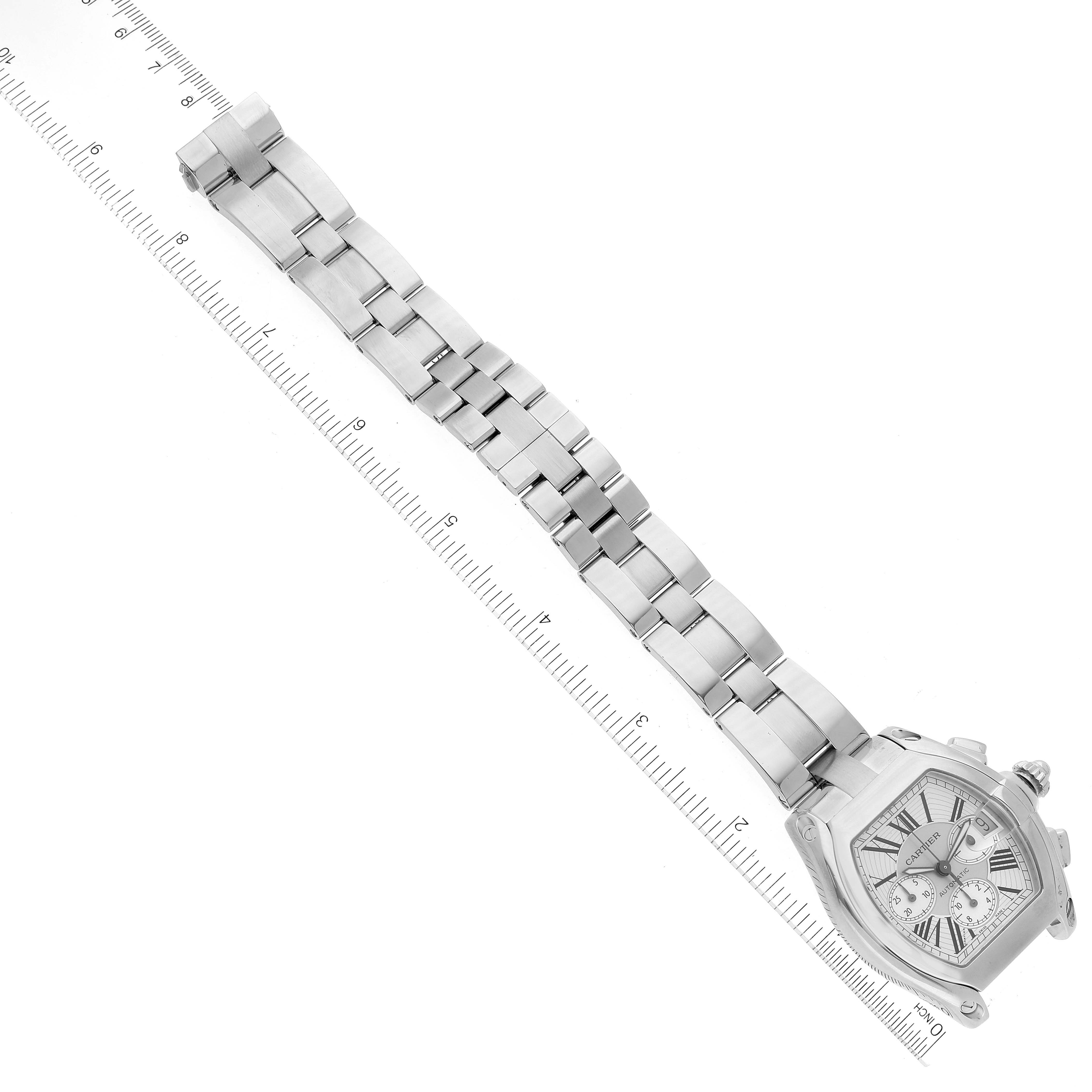 The image shows the Cartier Roadster W62019X6 Men's Stainless Steel Silver Dial W62019X6 Men's Stainless Steel Silver Dial watch, including its silver bracelet and dial face, positioned diagonally alongside a ruler for scale.