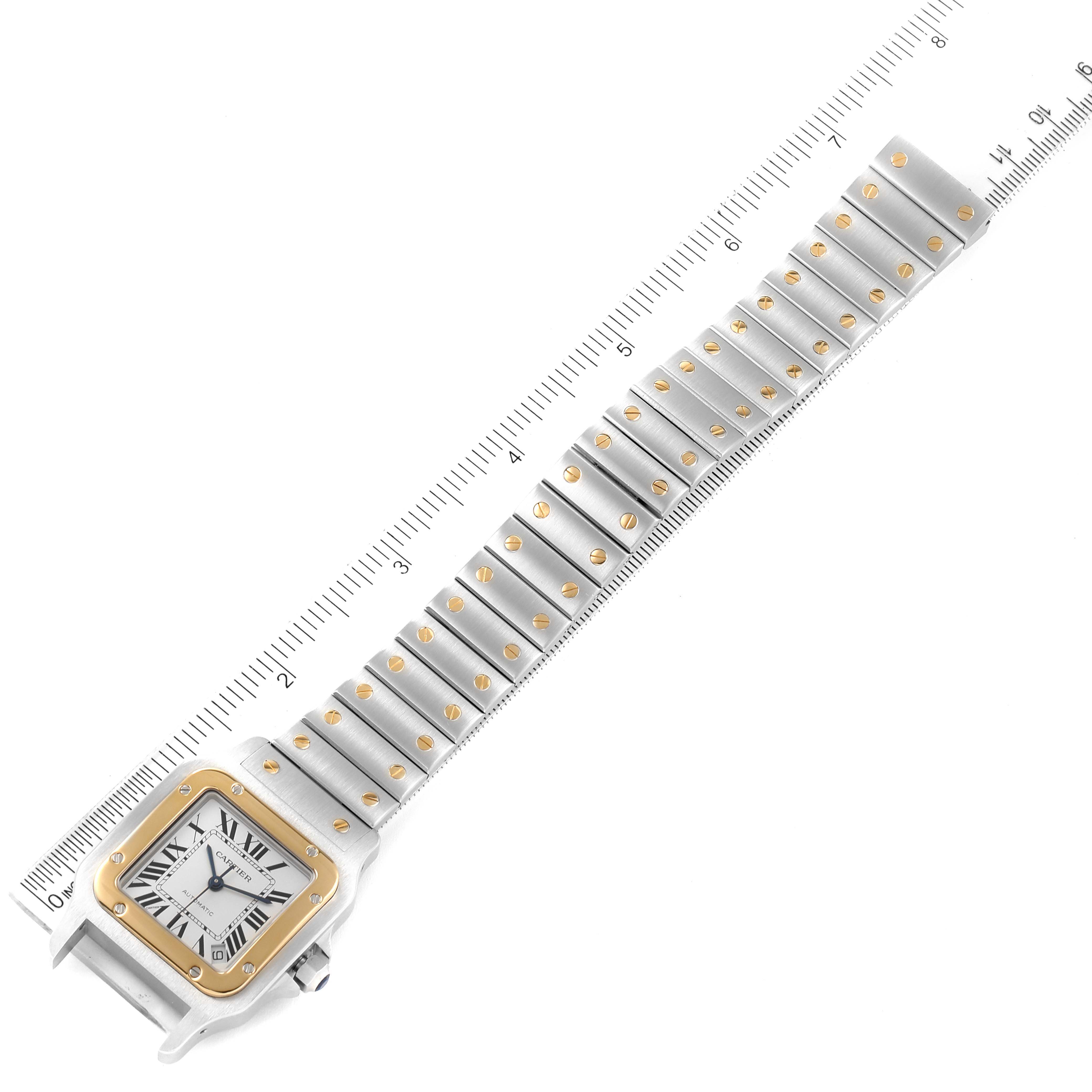 This image shows a top-down view of a Cartier Santos W20099C4 Men
s Steel and Gold (two tone) Silver Dial W20099C4 Men
s Steel and Gold (two tone) Silver Dial watch, highlighting the face and band with a ruler for scale.