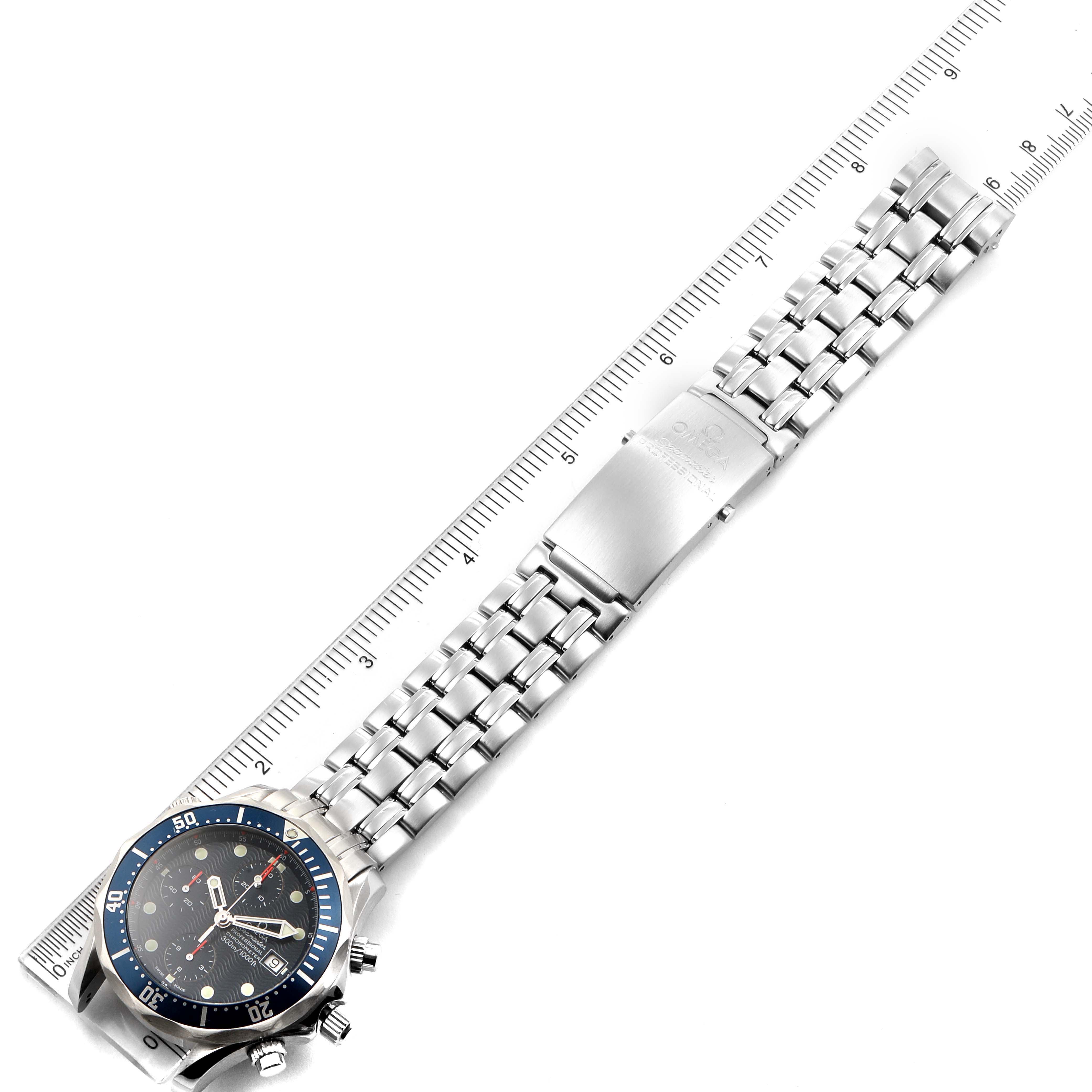 The image shows an Omega Seamaster 2599.80.00 Men
s Stainless Steel Blue Dial 2599.80.00 Men
s Stainless Steel Blue Dial watch laid flat with a visible blue bezel, watch face, and stainless steel bracelet next to a ruler.