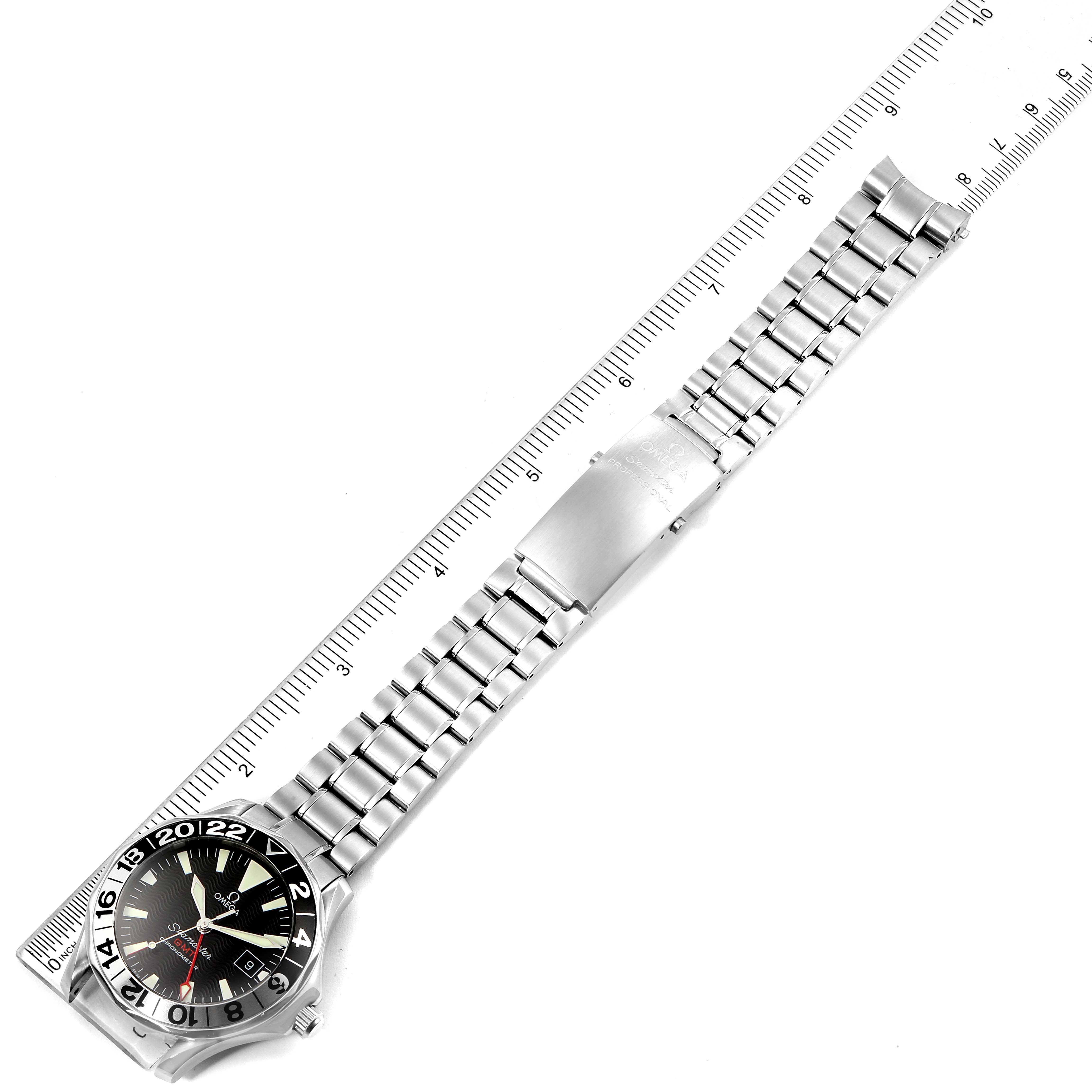 This image shows an Omega Seamaster 2536.50.00 Men's Stainless Steel Black Dial 2536.50.00 Men's Stainless Steel Black Dial watch laid flat next to a ruler, displaying the full bracelet and the face of the watch at an angle.