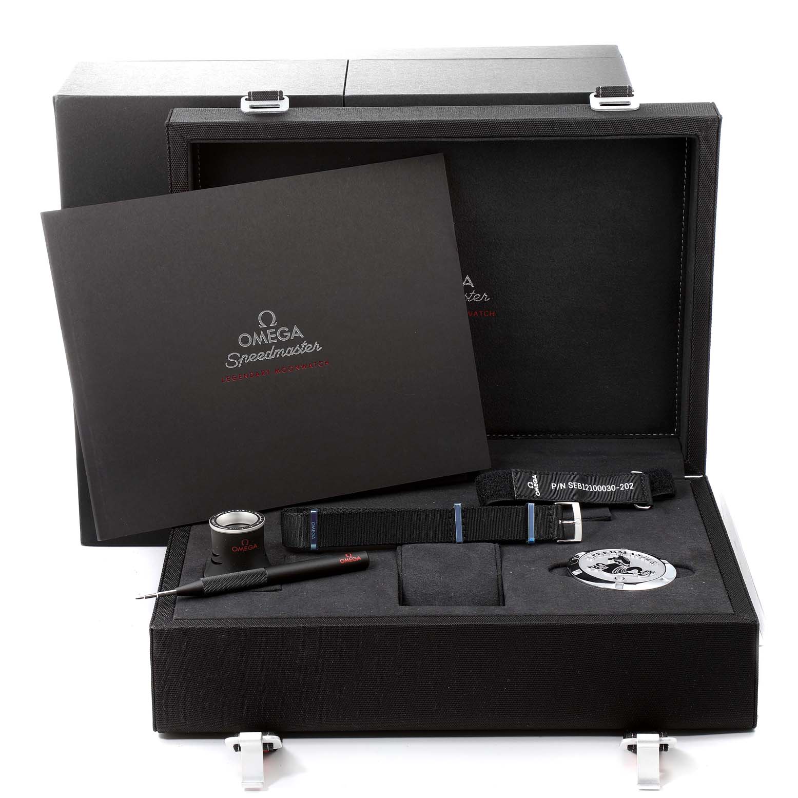 The image shows an Omega Speedmaster 311.30.42.30.01.006 Men
s Stainless Steel Black Dial 311.30.42.30.01.006 Men
s Stainless Steel Black Dial watch box and accessories, including a manual, strap, loupe, and tool from a top angle.