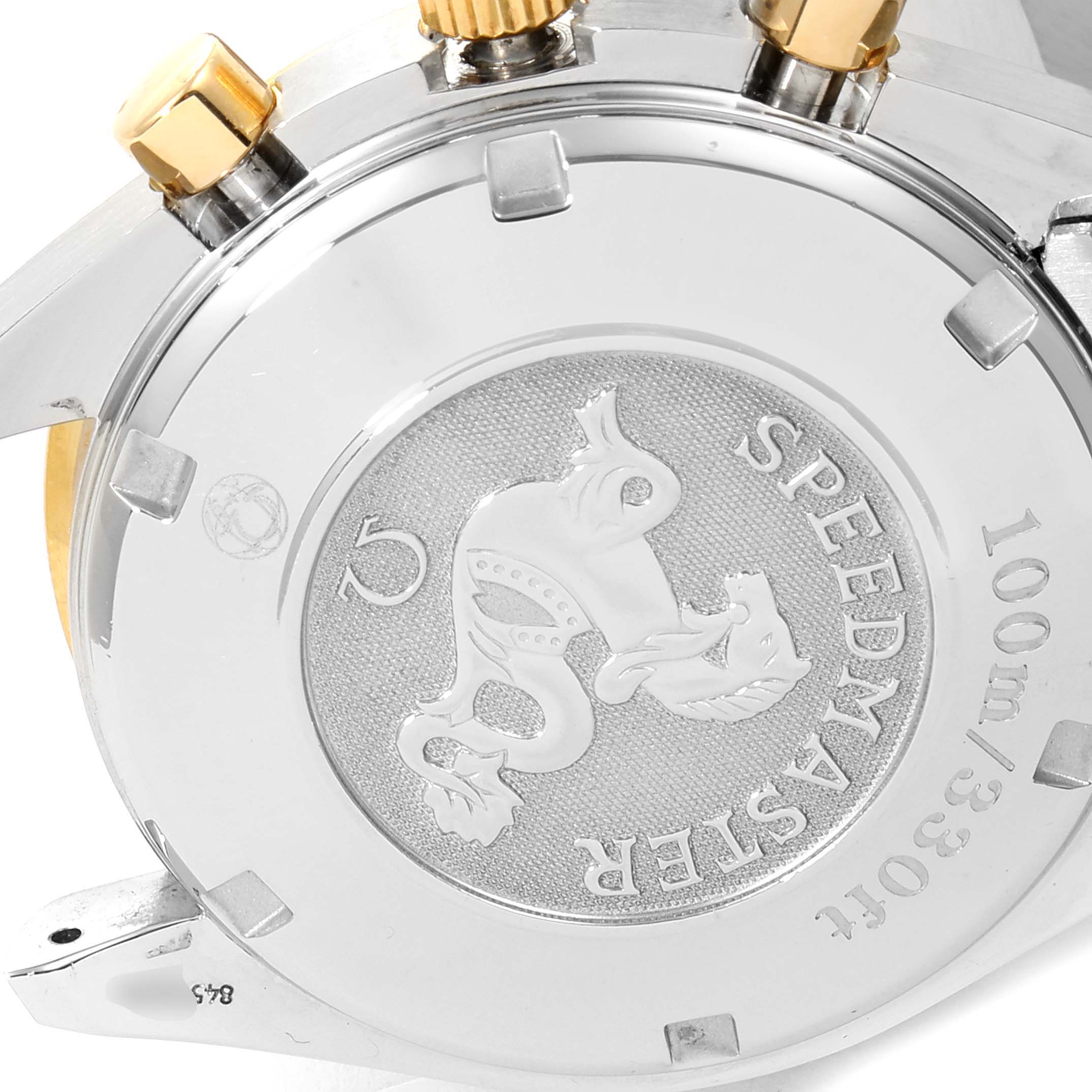 The image shows the back case and crown of an Omega Speedmaster 323.21.40.44.02.001 Men's Steel and Gold (two tone) Silver Dial 323.21.40.44.02.001 Men's Steel and Gold (two tone) Silver Dial watch from an angled, close-up view.