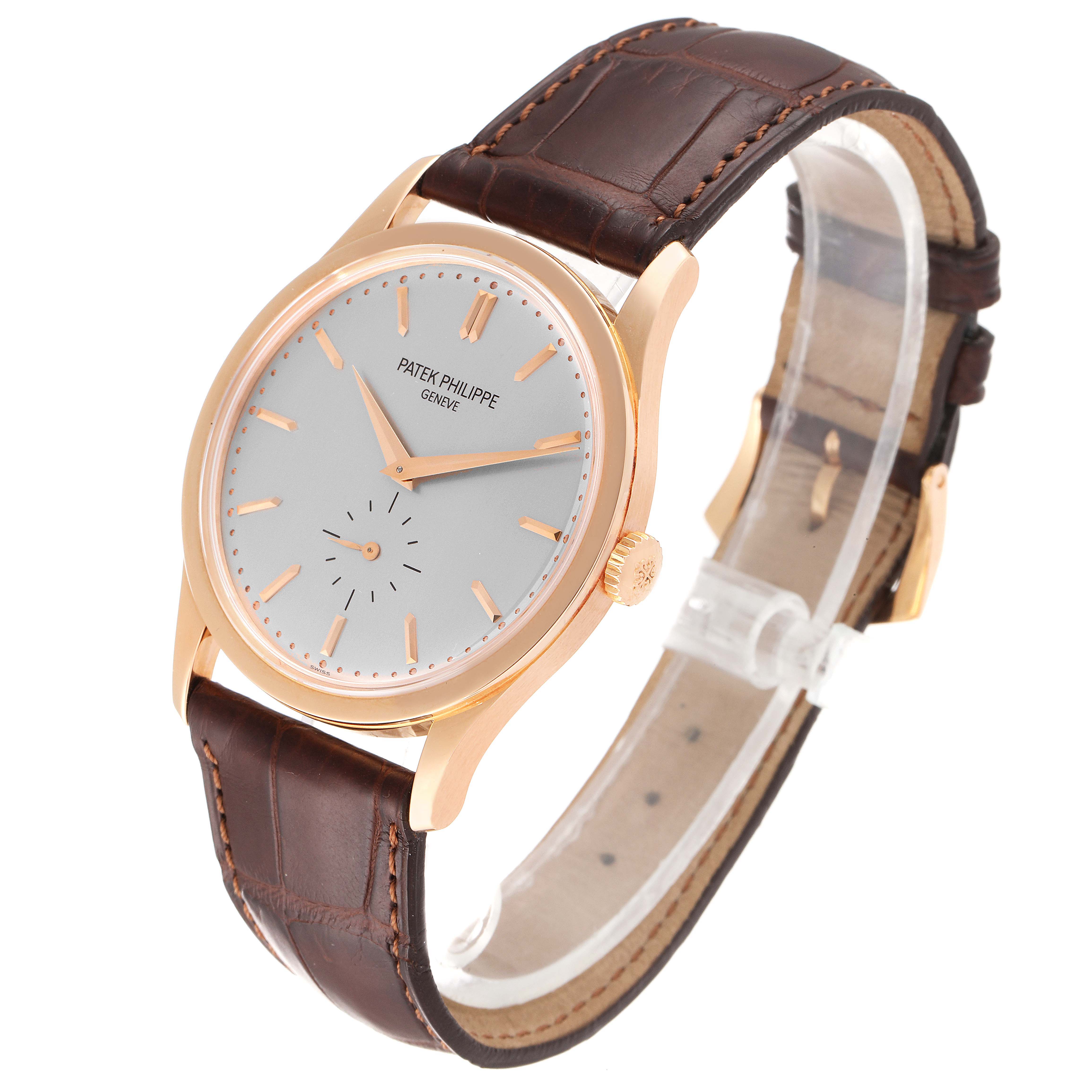 The image shows a Calatrava model by Patek Philippe at a three-quarter view, displaying the watch face and brown leather strap.