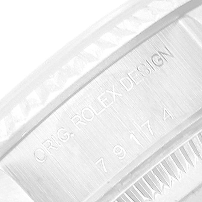 The image shows an extreme close-up of the engraved inner bezel of a Rolex Datejust 79174 Women's Stainless Steel Silver Dial 79174 Women's Stainless Steel Silver Dial watch, featuring the inscription "ORIG. ROLEX DESIGN" and a serial number.