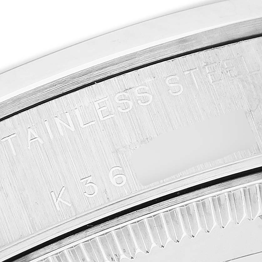 The image shows a close-up of the case back and edge of a Mid-Size Rolex watch, highlighting its engravings.