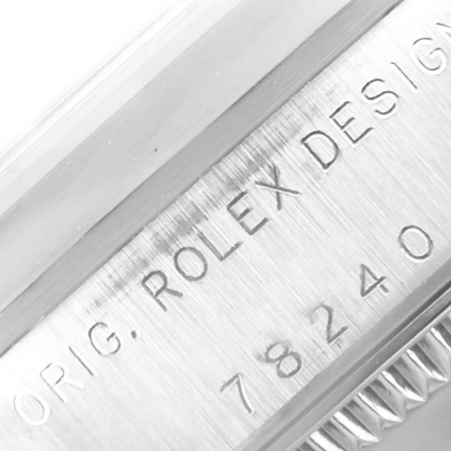 This close-up image of the Rolex Mid-Size 78240 Women's Stainless Steel Pink Dial 78240 Women's Stainless Steel Pink Dial model shows the engraved "ROLEX DESIGN" text and part of the bezel.